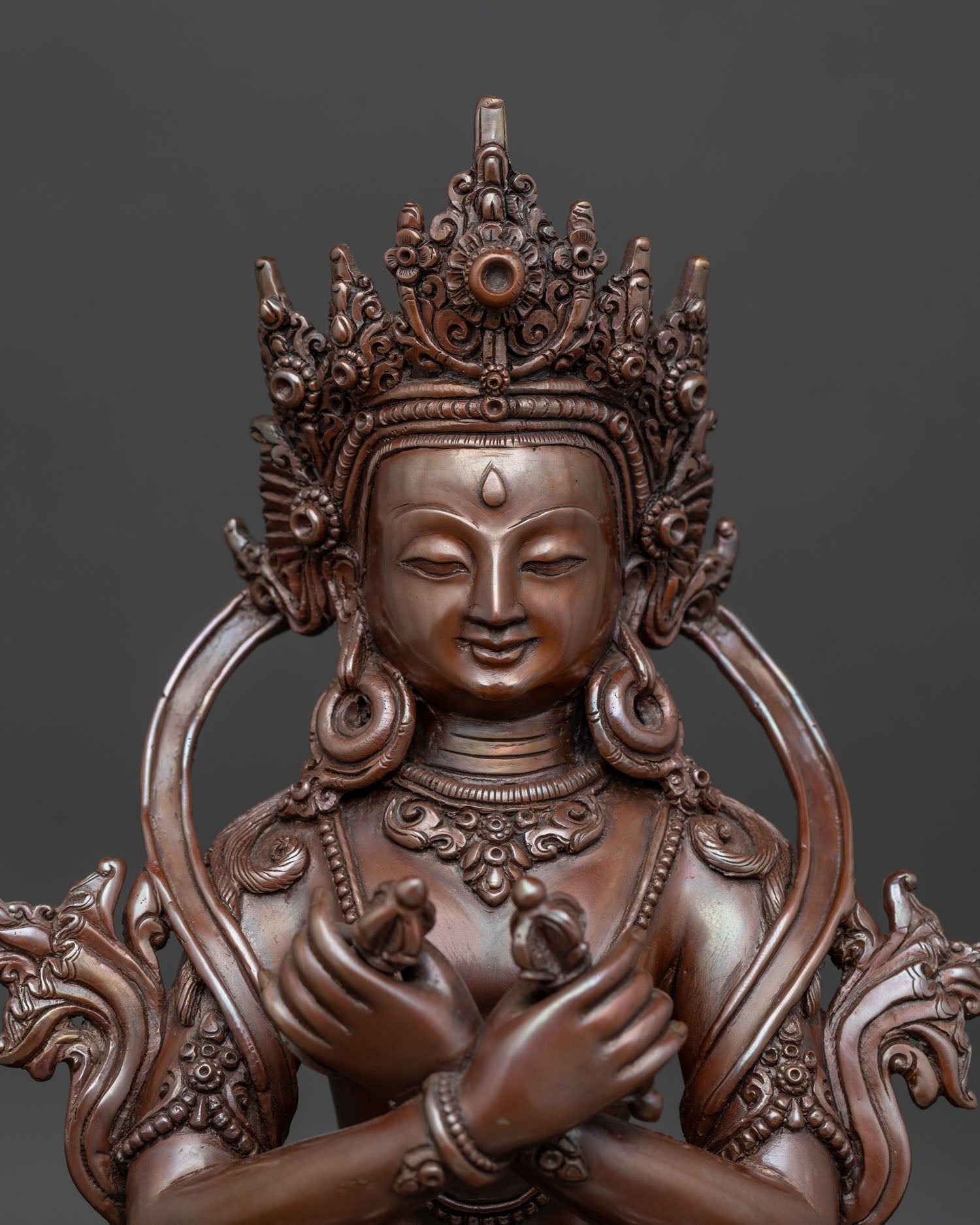 Close up view of Vajradhara holding vajra and bell with sacred ornaments