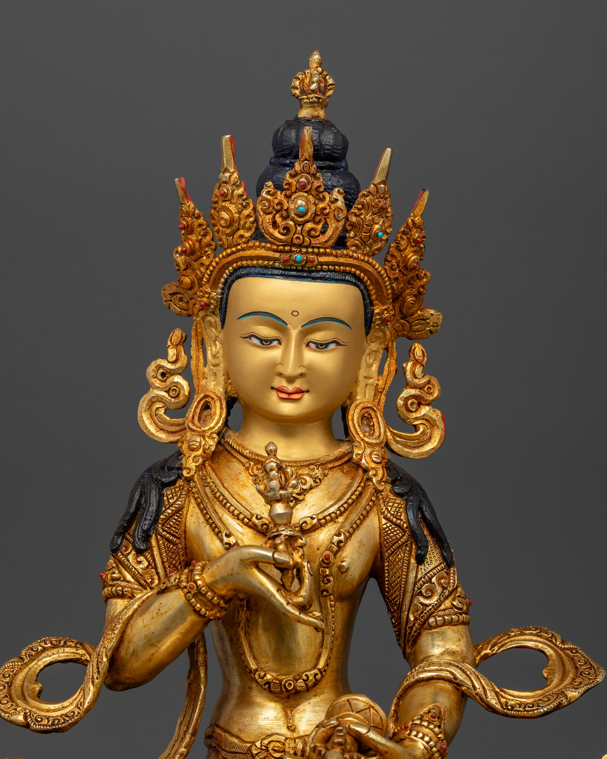 Close up view of Vajrasattva with gold painted face and semi precious stone details