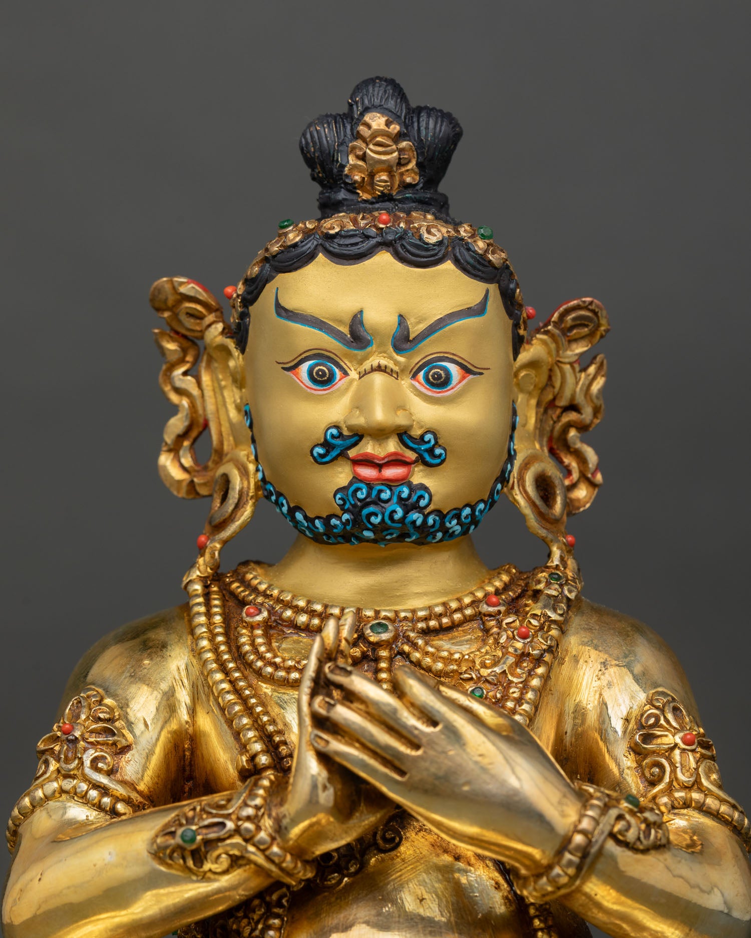 Close up Virupa statue gold painted face semi precious stones detail Himalayan Buddhist artisan sculpture Kathmandu Valley