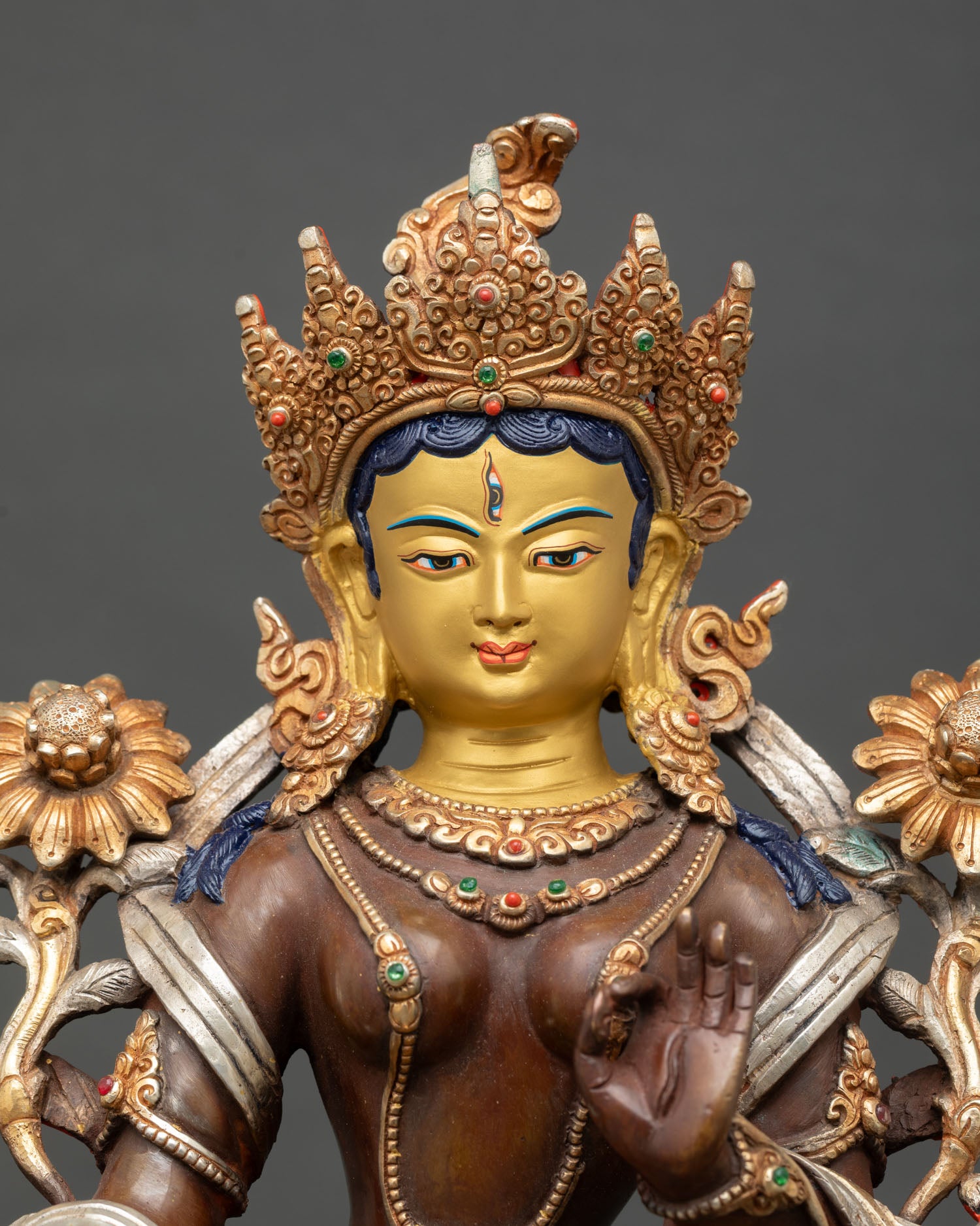 Close up White Tara face with 24K gold painted serene expression and seven eyes symbolizing compassion and awareness