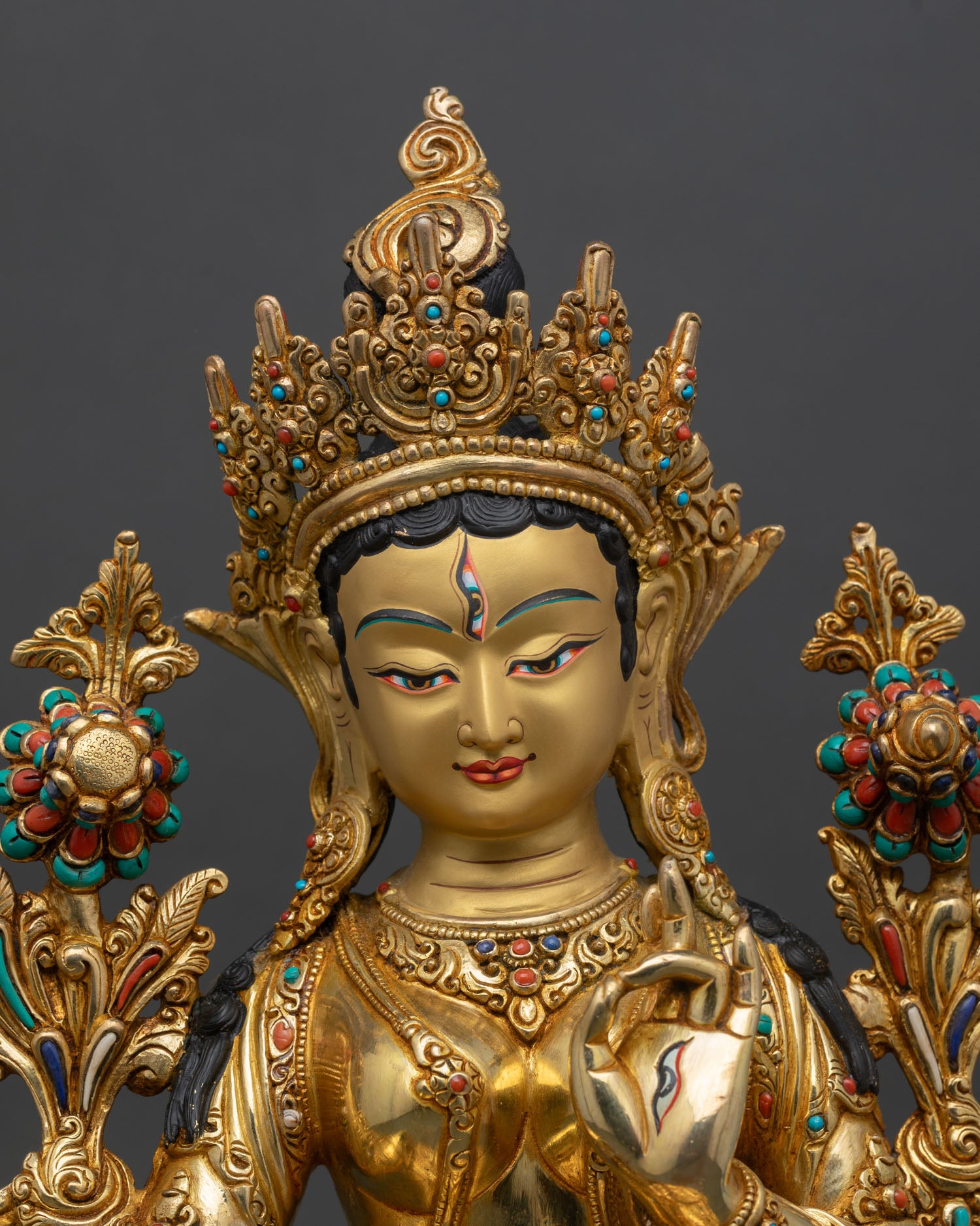 Close up white tara face seven eyes gold gilded copper statue patan nepal fine detailing expression