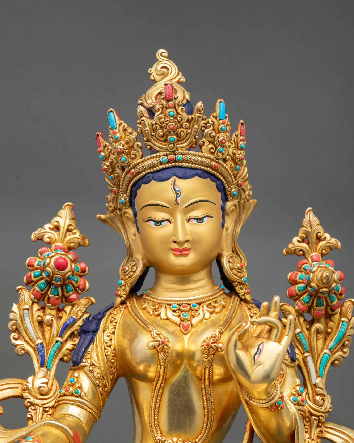 Close up  White Tara face with compassionate expression gold detailing and semi precious stone inlays