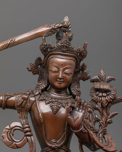 close-up of Manjushri’s face and crown with oxidized copper detail and intricate carvings
