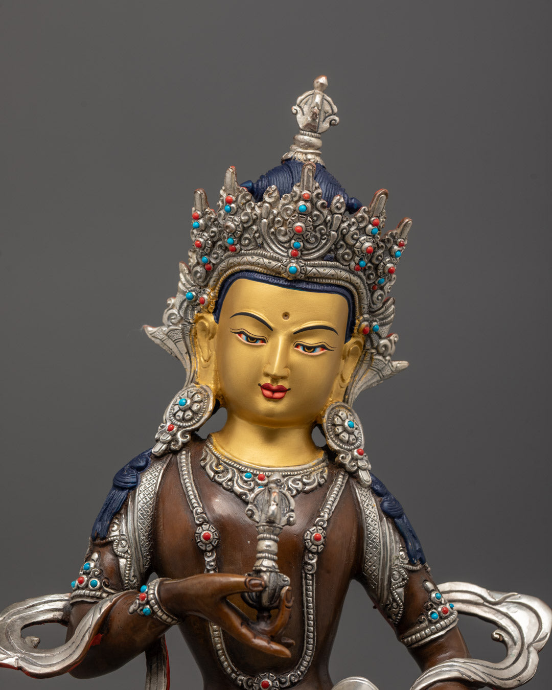 close-up of Vajrasattva’s jeweled crown, serene face, and semi-precious stone details