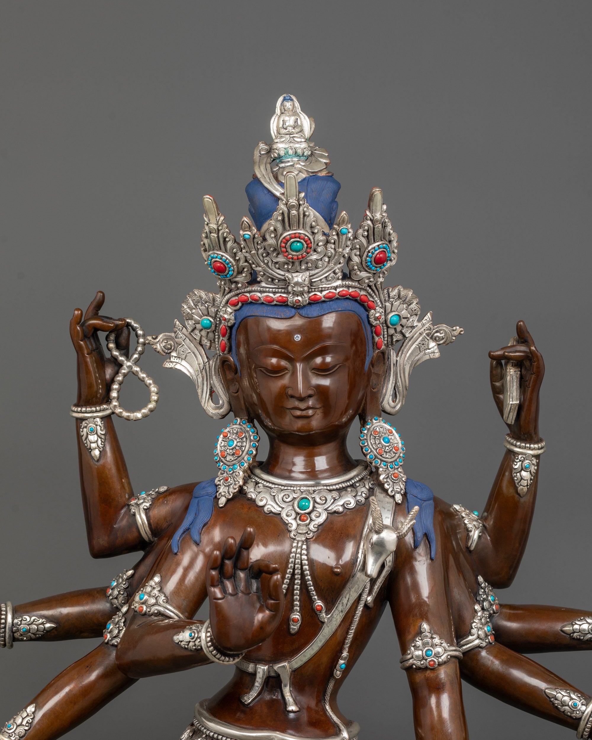 close-up of amoghapasa lokeshvara statue showing jeweled crown and semi-precious stone details