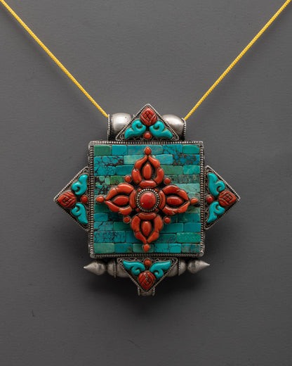 close-up of coral Double Vajra symbol on intricately carved silver locket
