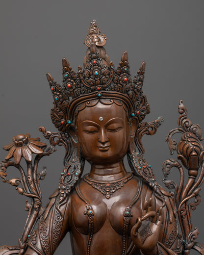 close-up of green tara statue face showing oxidized copper finish and fine details