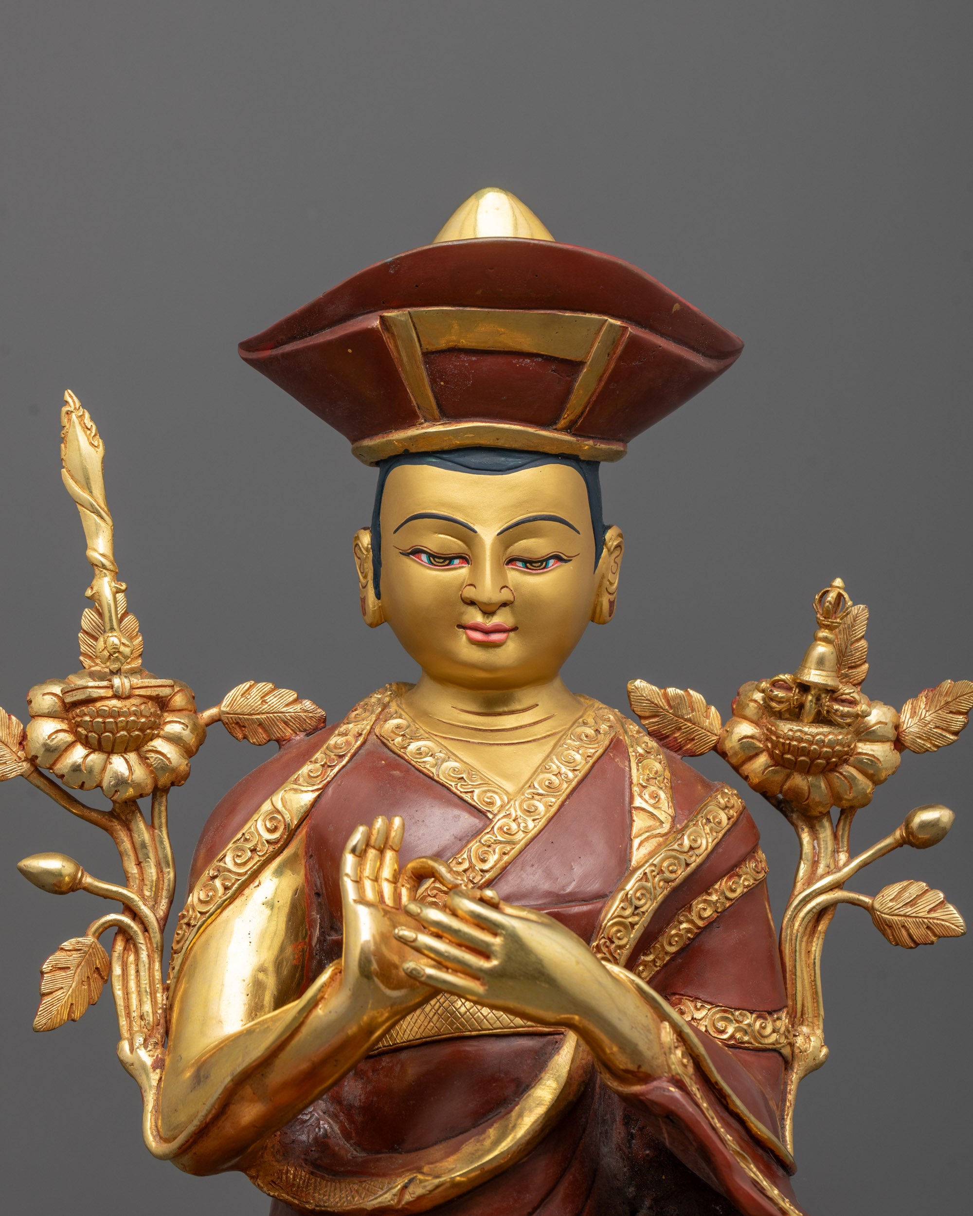 close-up of nyamme sherab gyaltsen statue showing gold-plated face and utpala flower detail