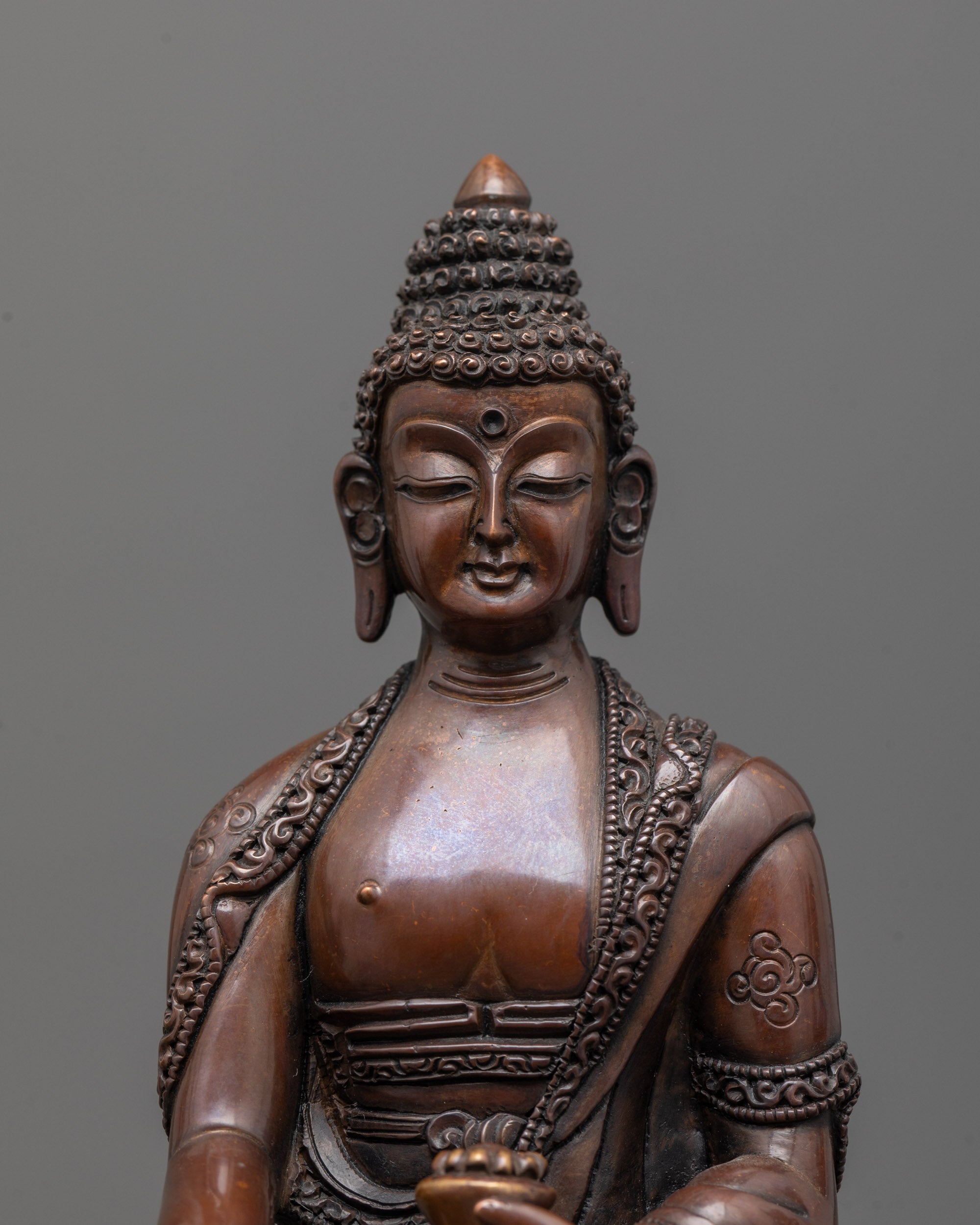close-up of shakyamuni buddha statue face with halo and intricate lost wax casting details