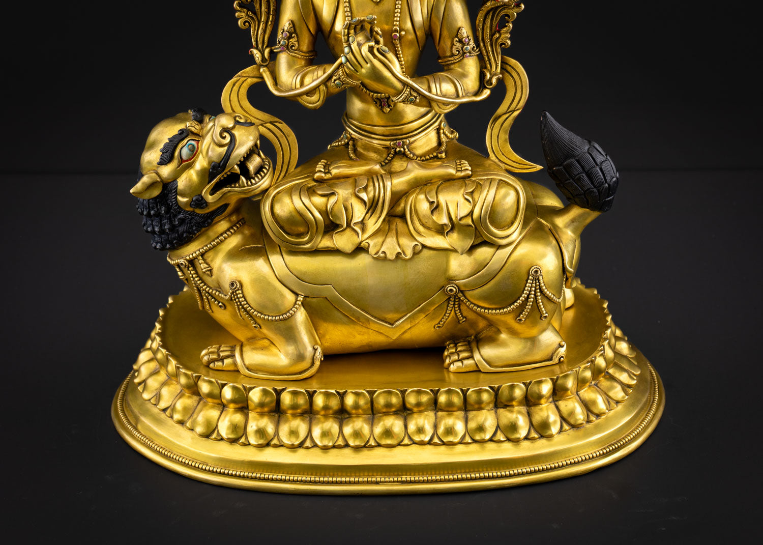 Close view of lion throne detail showing roaring expression and finely carved base supporting Manjushri statue representing fearless wisdom and traditional Nepalese Newari metal artistry