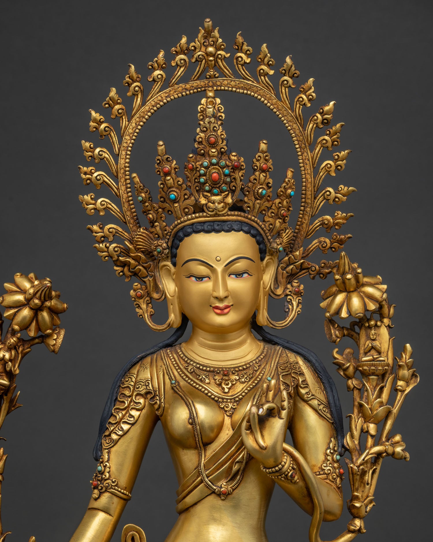 close view of standing green tara statue showing ornate crown and gold gilded details