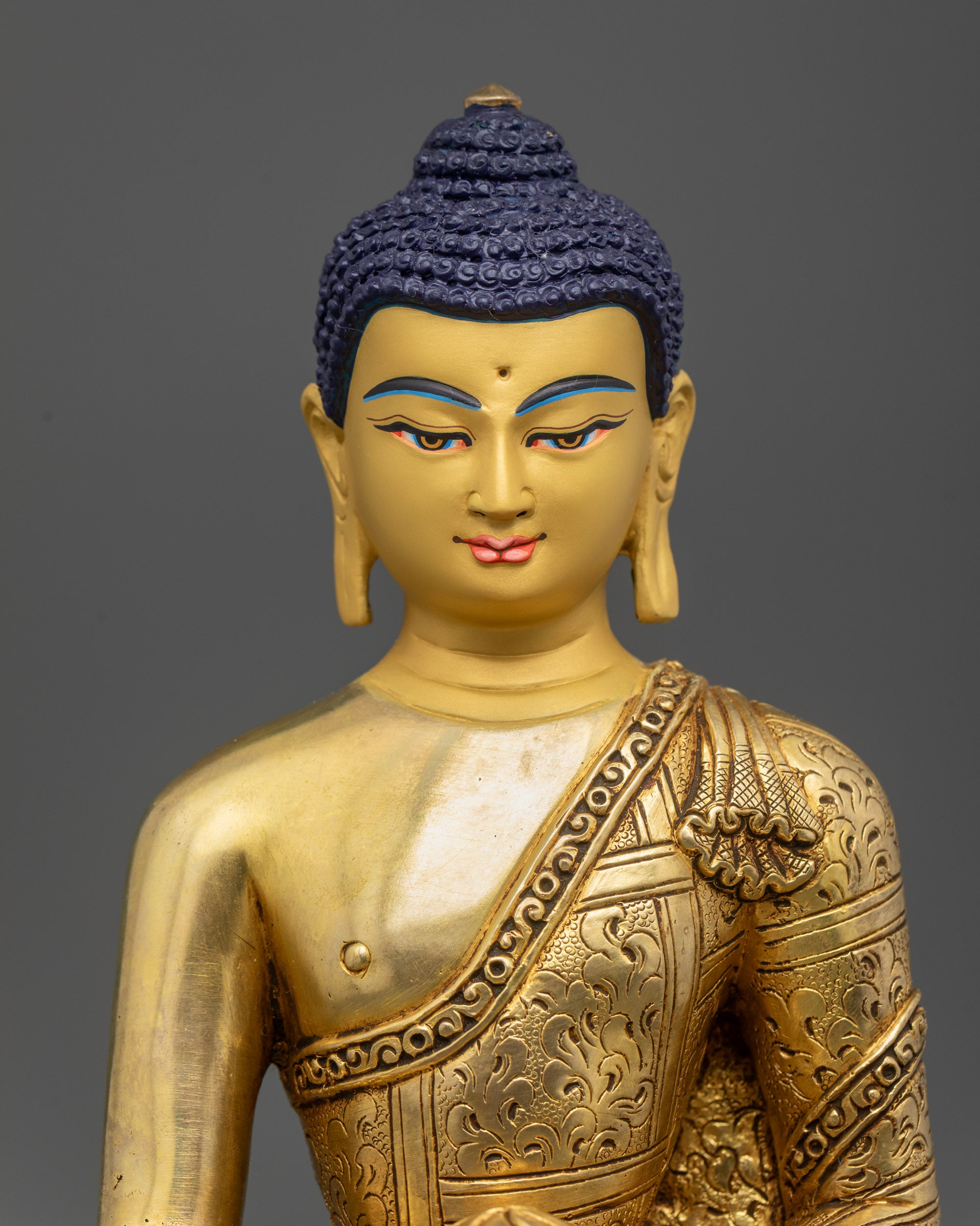 close up Golden Shakyamuni Buddha face showing Bhumisparsha Mudra and alms bowl detail