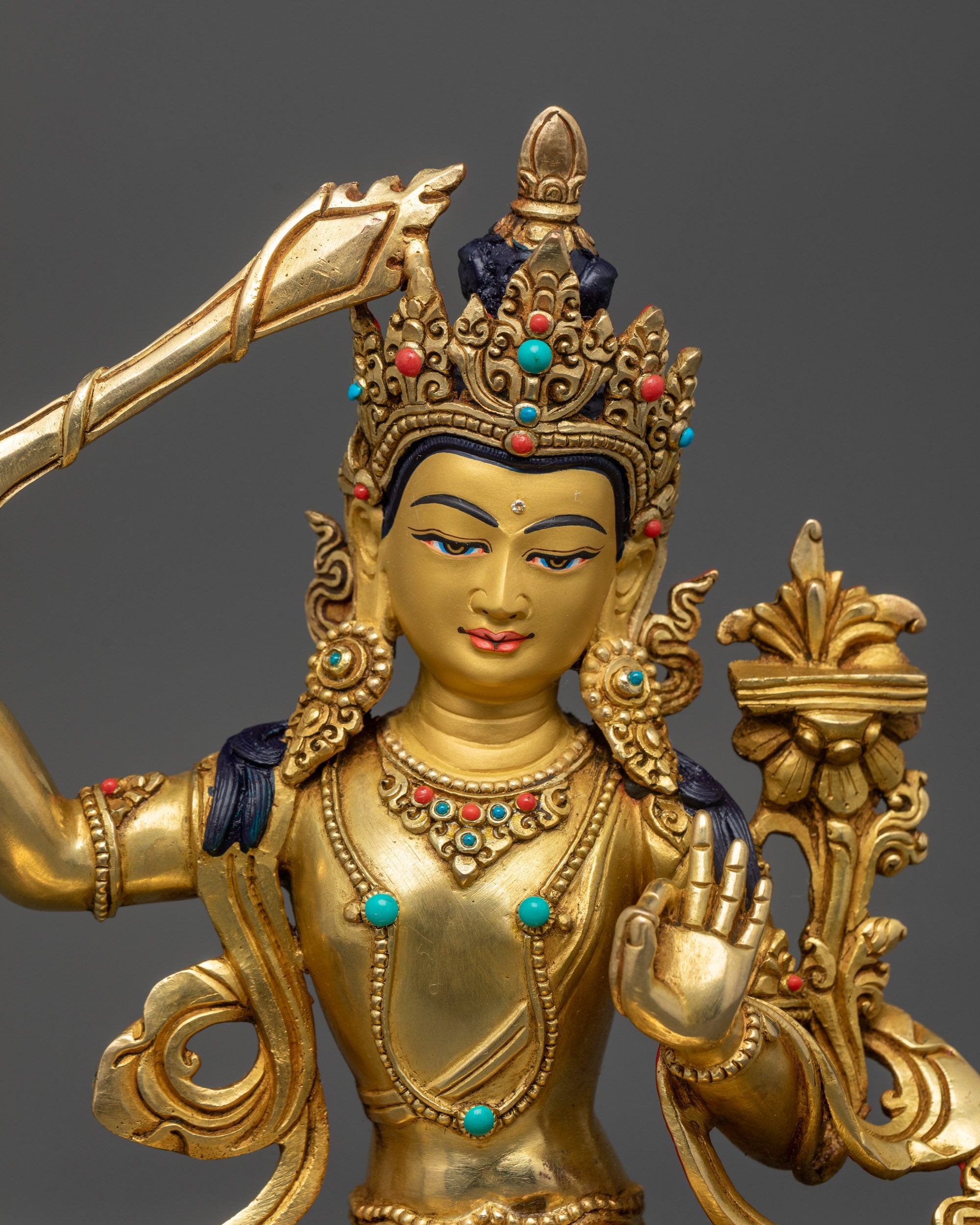 close up Manjushri face showing utpala flower and wisdom flame sword details