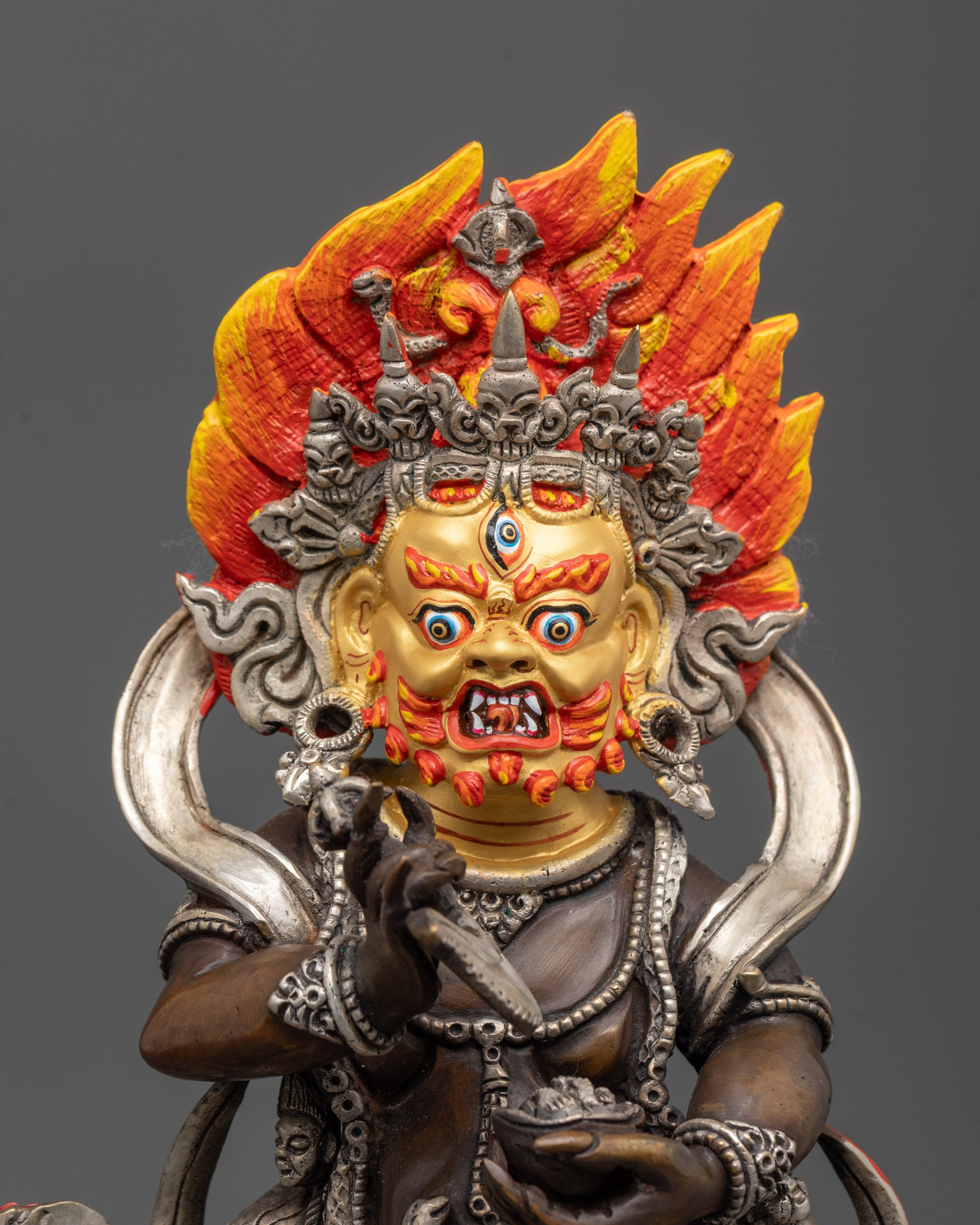 close up Sakya Mahakala statue showing wrathful face and five-skull crown in fine detail