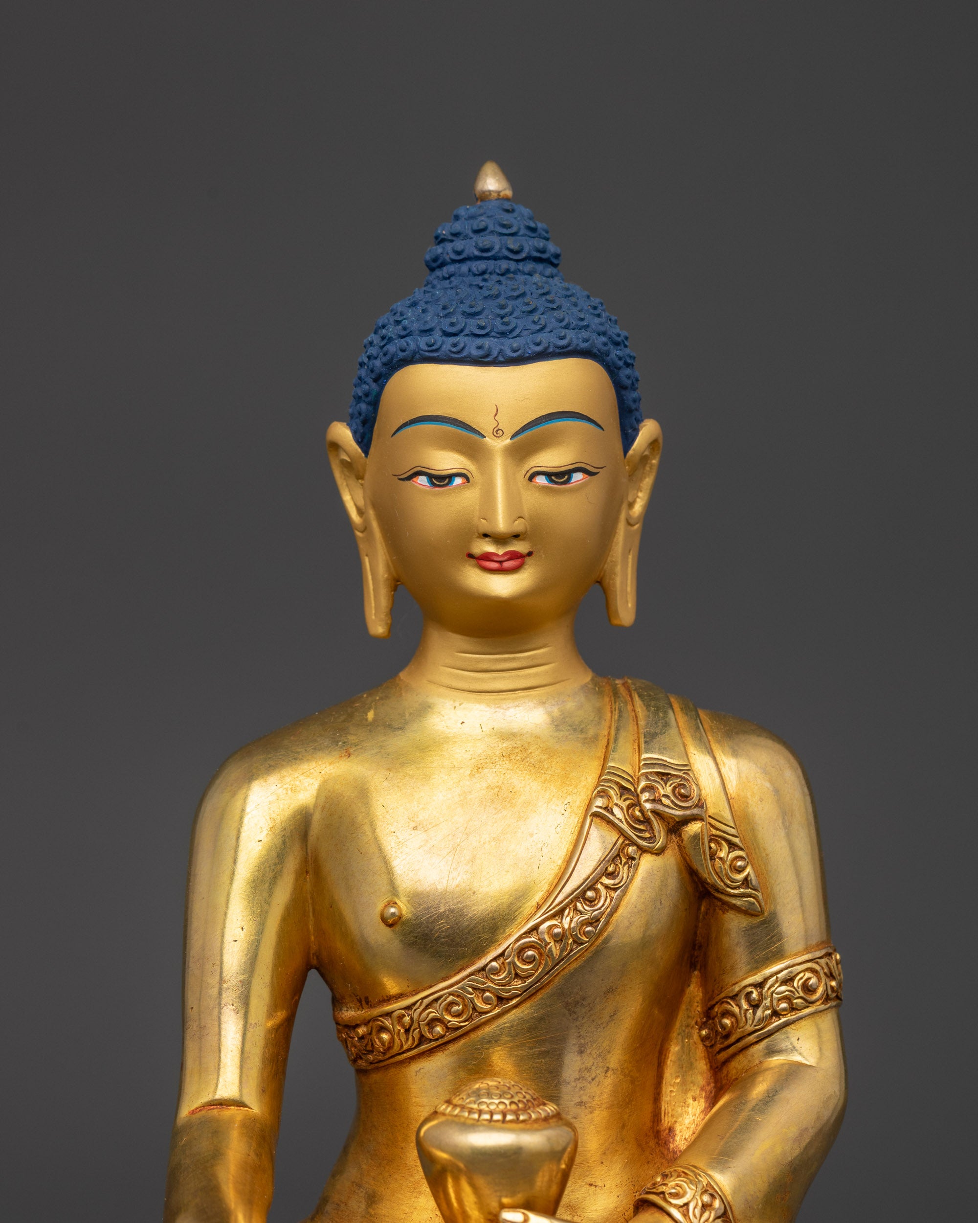 close up Shaka Nyorai Buddha face showing serene gold gilded expression