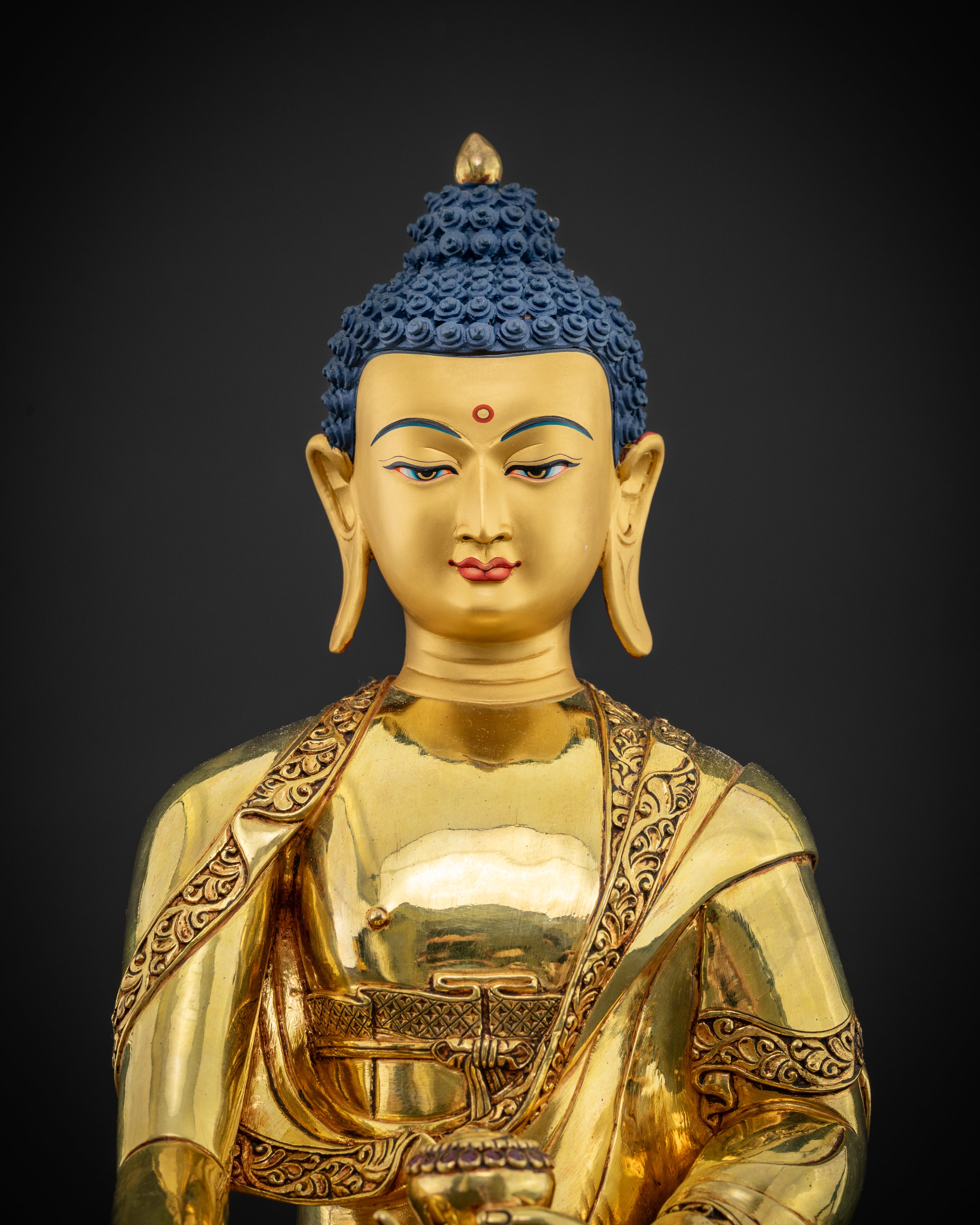 close up Shakyamuni Buddha statue intricate robe detailing gold-painted serene face Nepal craftsmanship