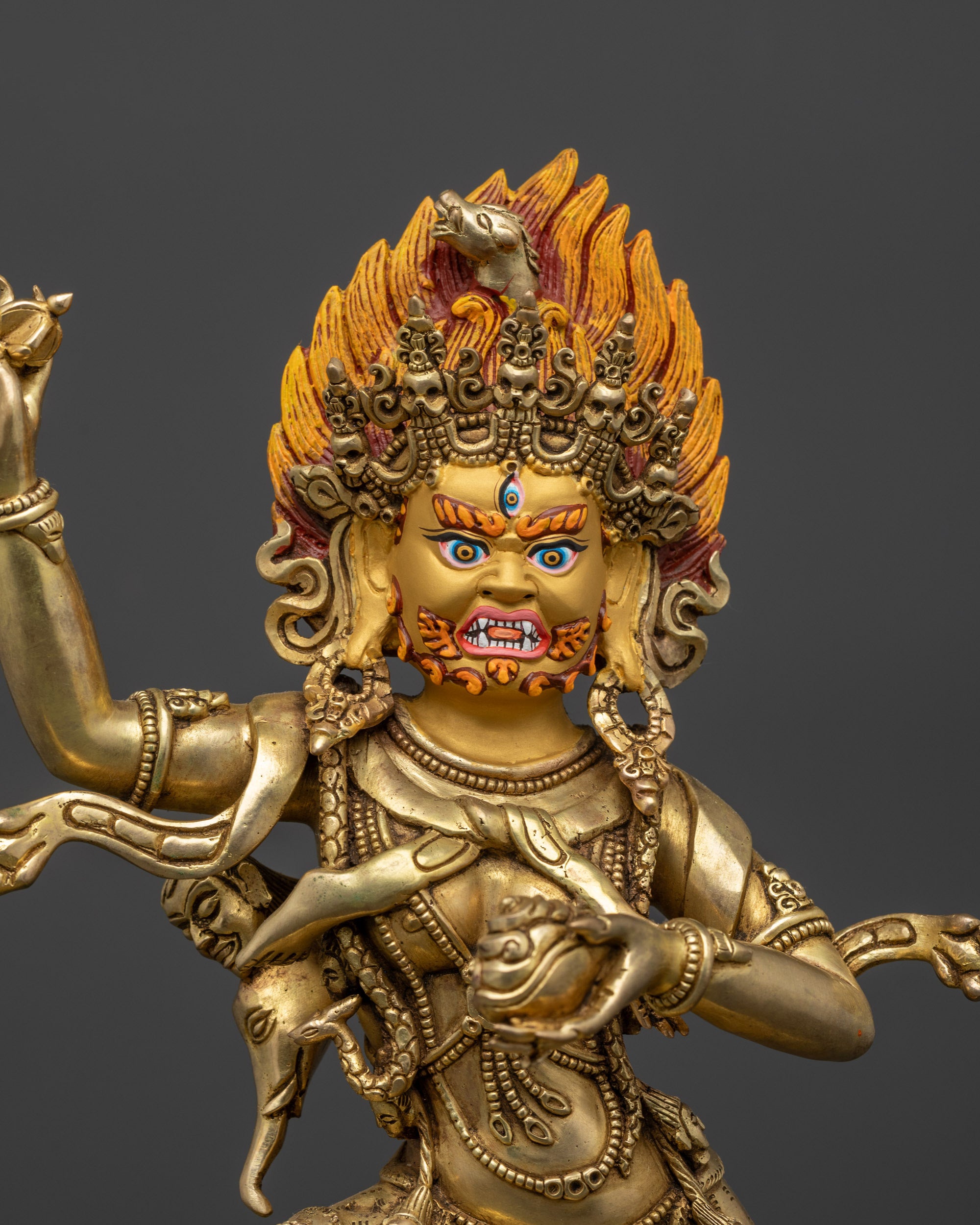 close up Troma Nagmo statue face with three eyes and five skull crown details
