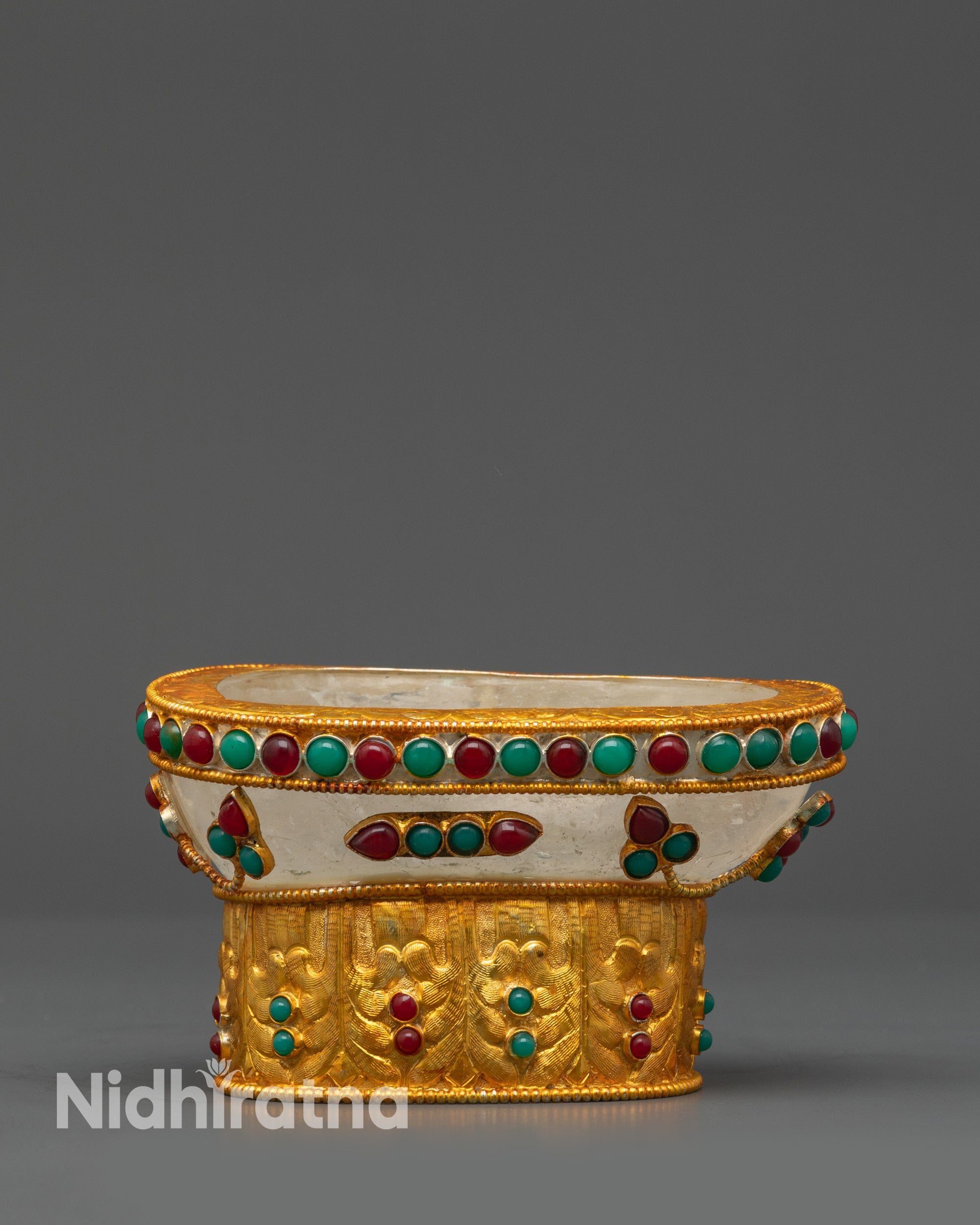 close up gold-plated ritual skull bowl showing detailed stone inlay patterns
