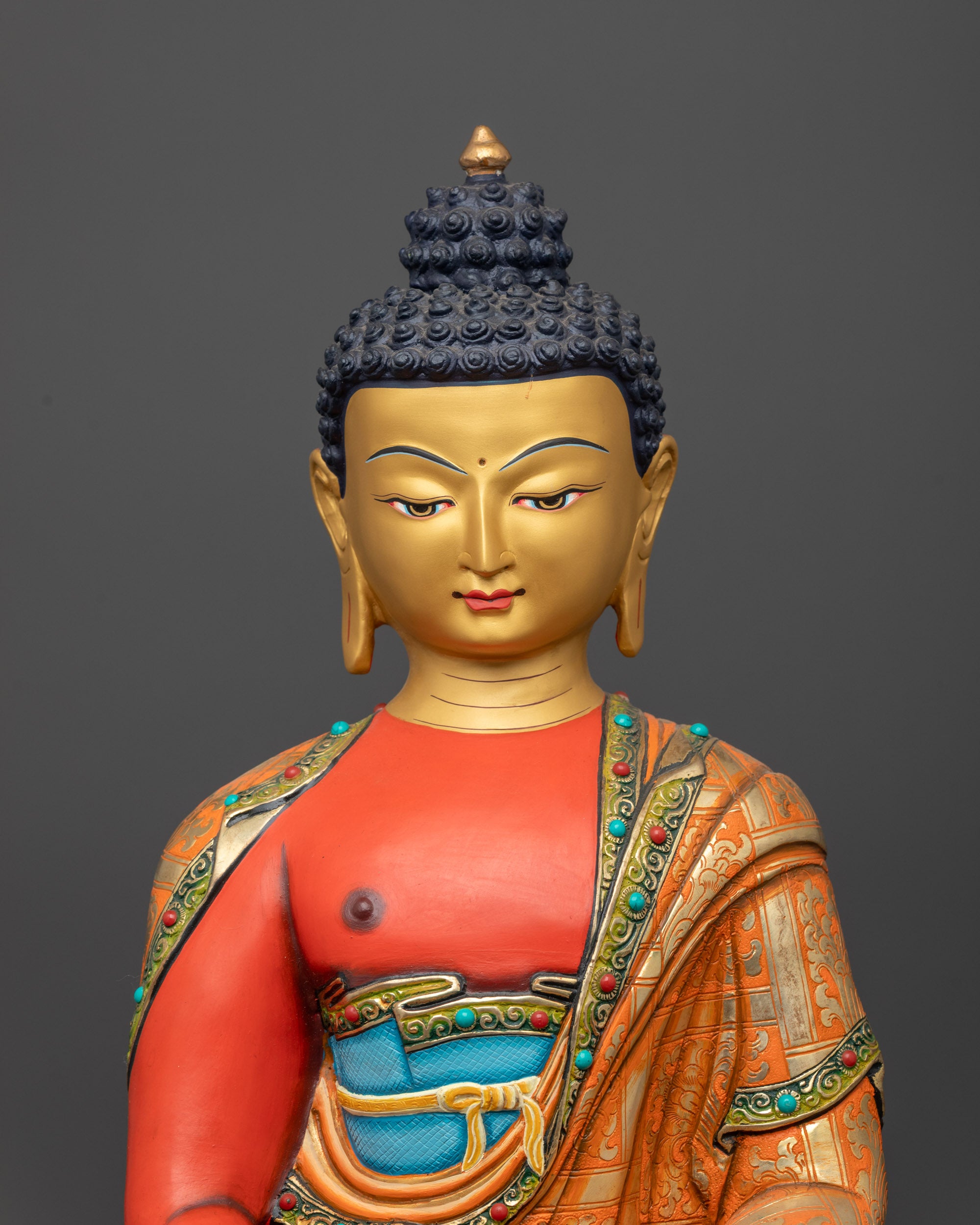 close up of Amitabha Buddha Statue showing intricate red-painted body and sacred symbols
