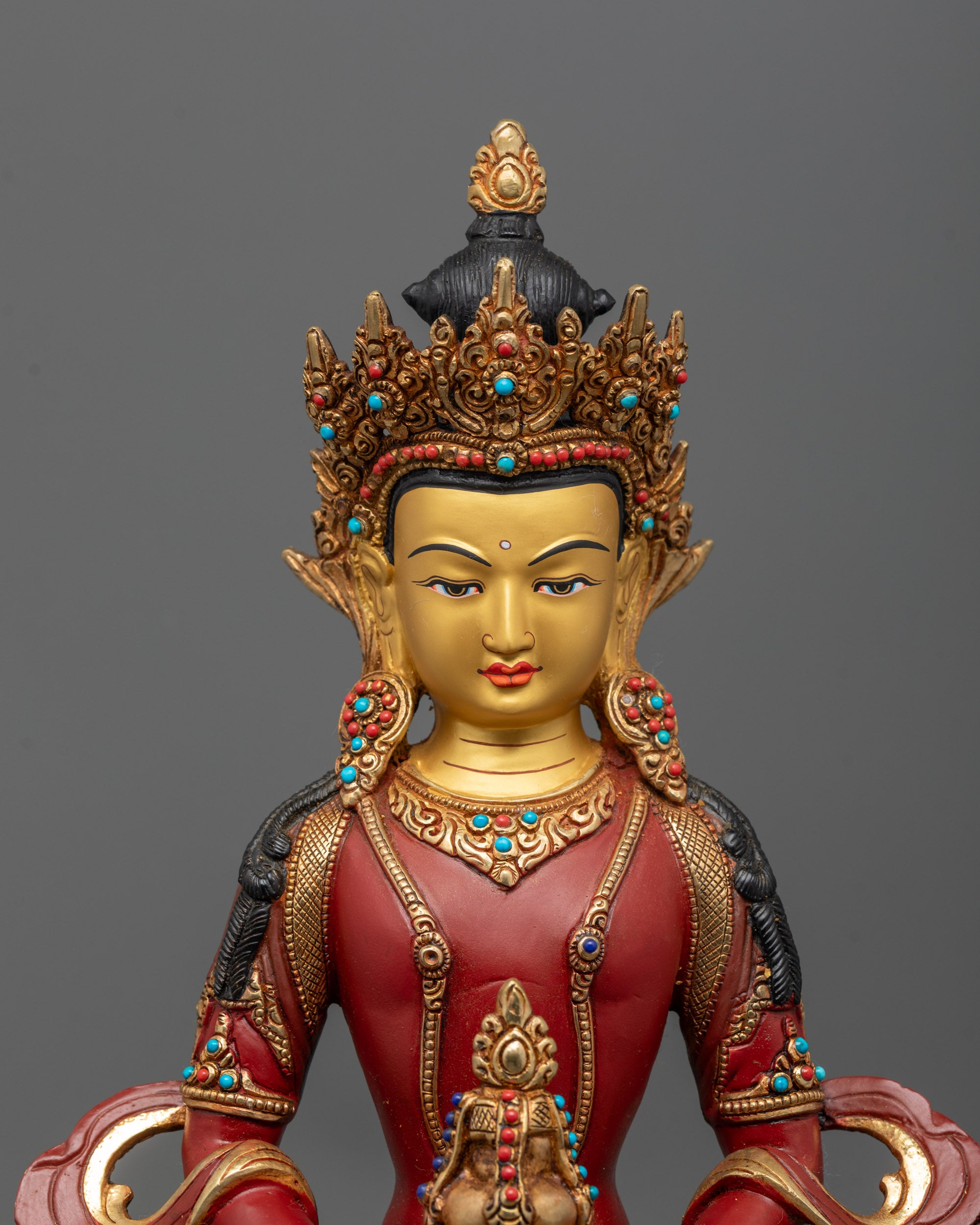 close up of Amitayus gold-gilded face with nectar vase and semi-precious stones