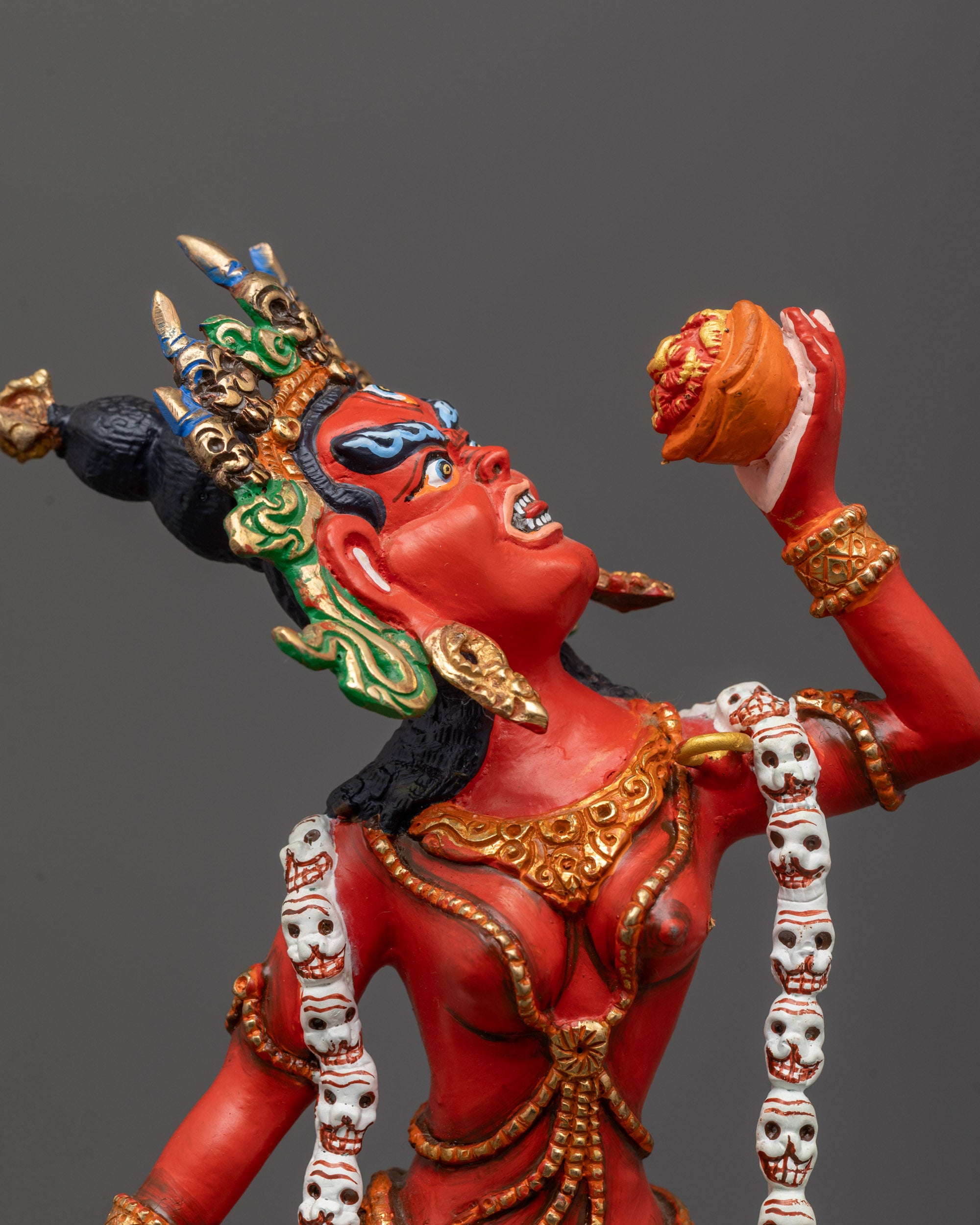 close up of Vajrayogini face and khatvanga trident with fine gold-plated detailing