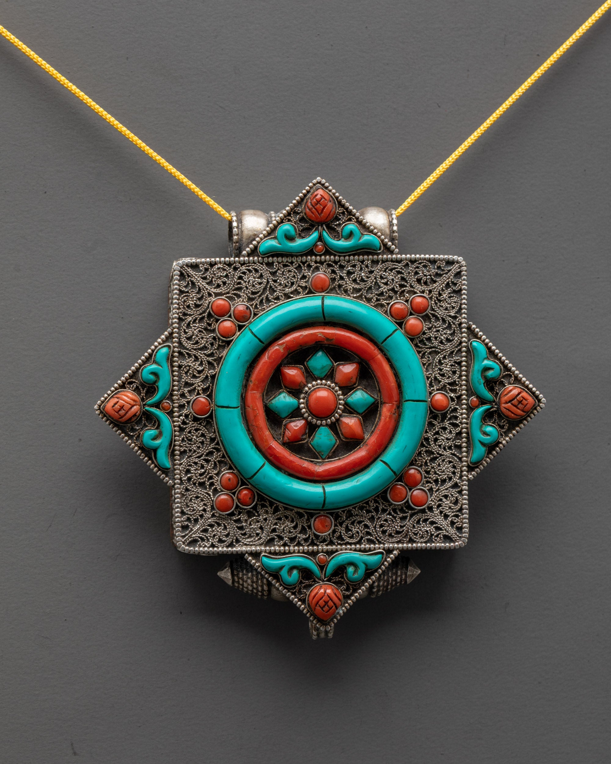 close up of dharma wheel symbol with intricate silver filigree and vibrant gemstone inlays