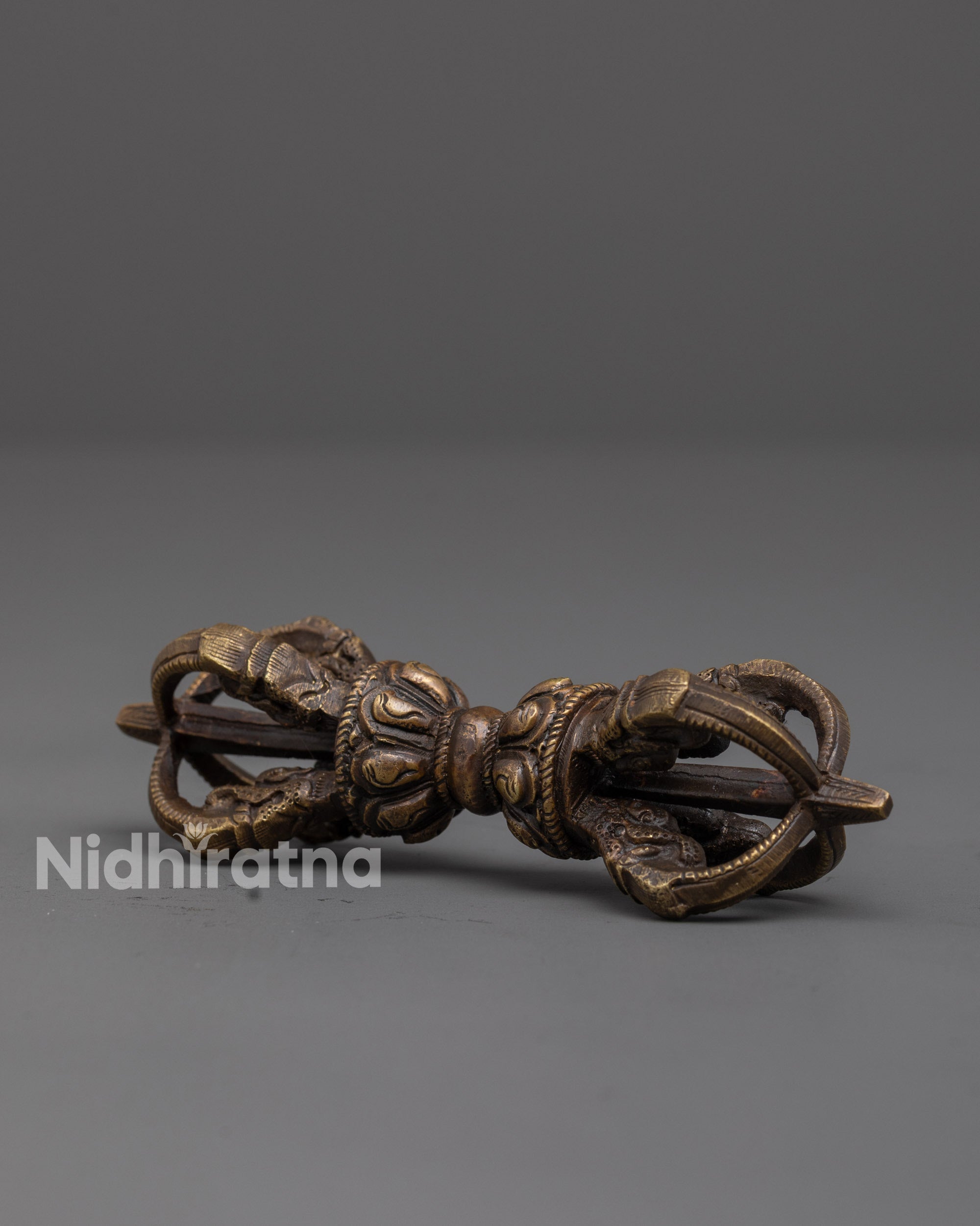 close up of handcrafted bronze vajra with intricate patterns for tibetan rituals