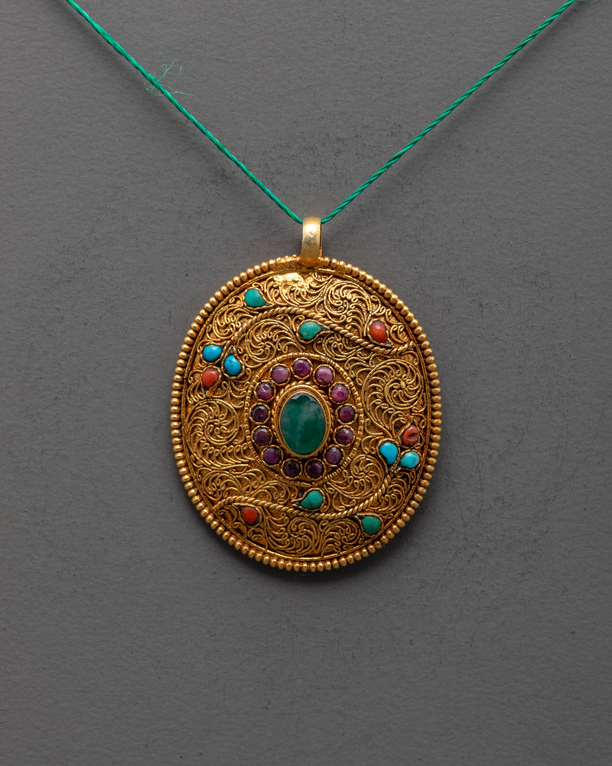 close up of intricate filigree design on Tibetan flower locket with ruby coral turquoise stones