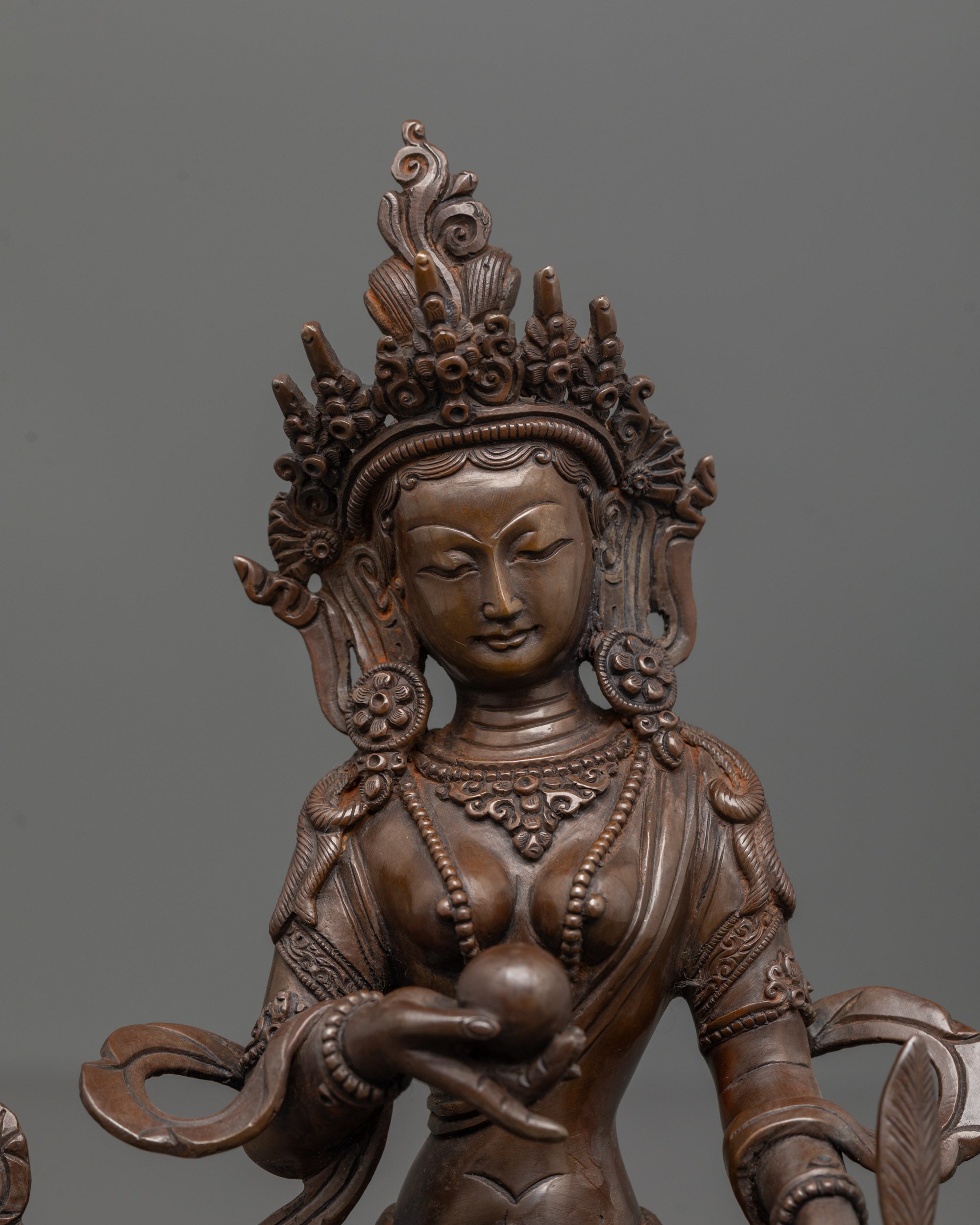 close up of ksitigarbha statue crown and chintamani in oxidized copper finish