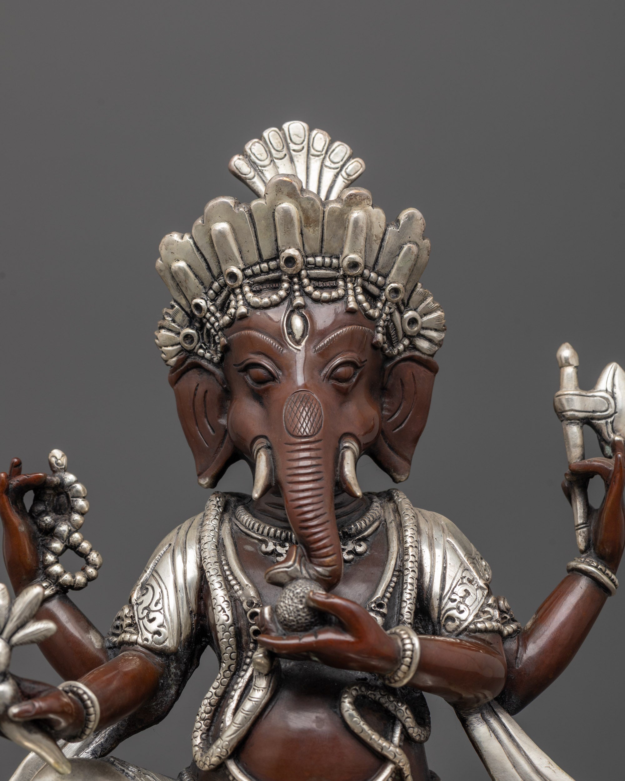close up of oxidized copper face and silver-plated body of handcrafted ganesha idol