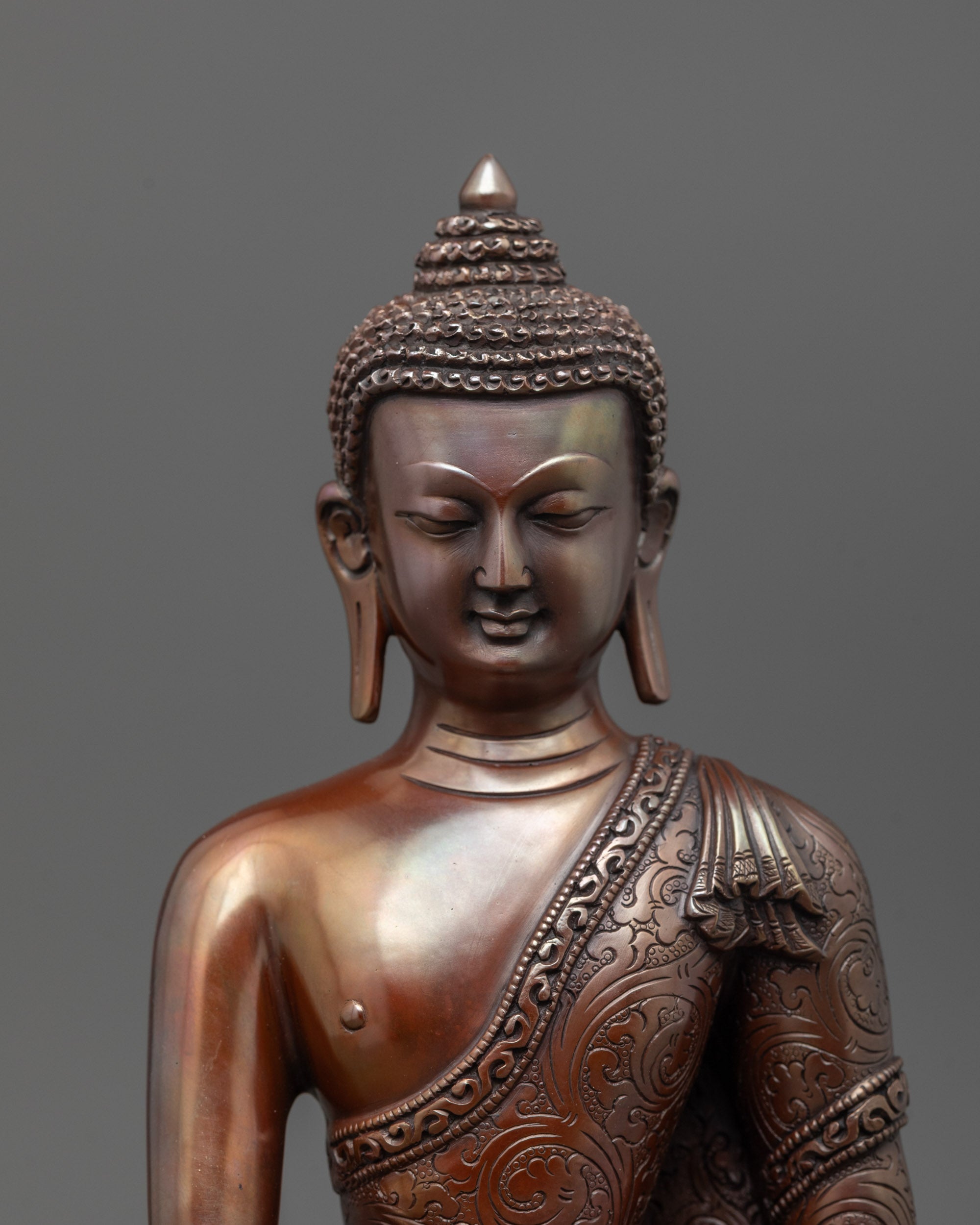 close up of oxidized copper shakyamuni buddha statue with carved patterns and patra bowl