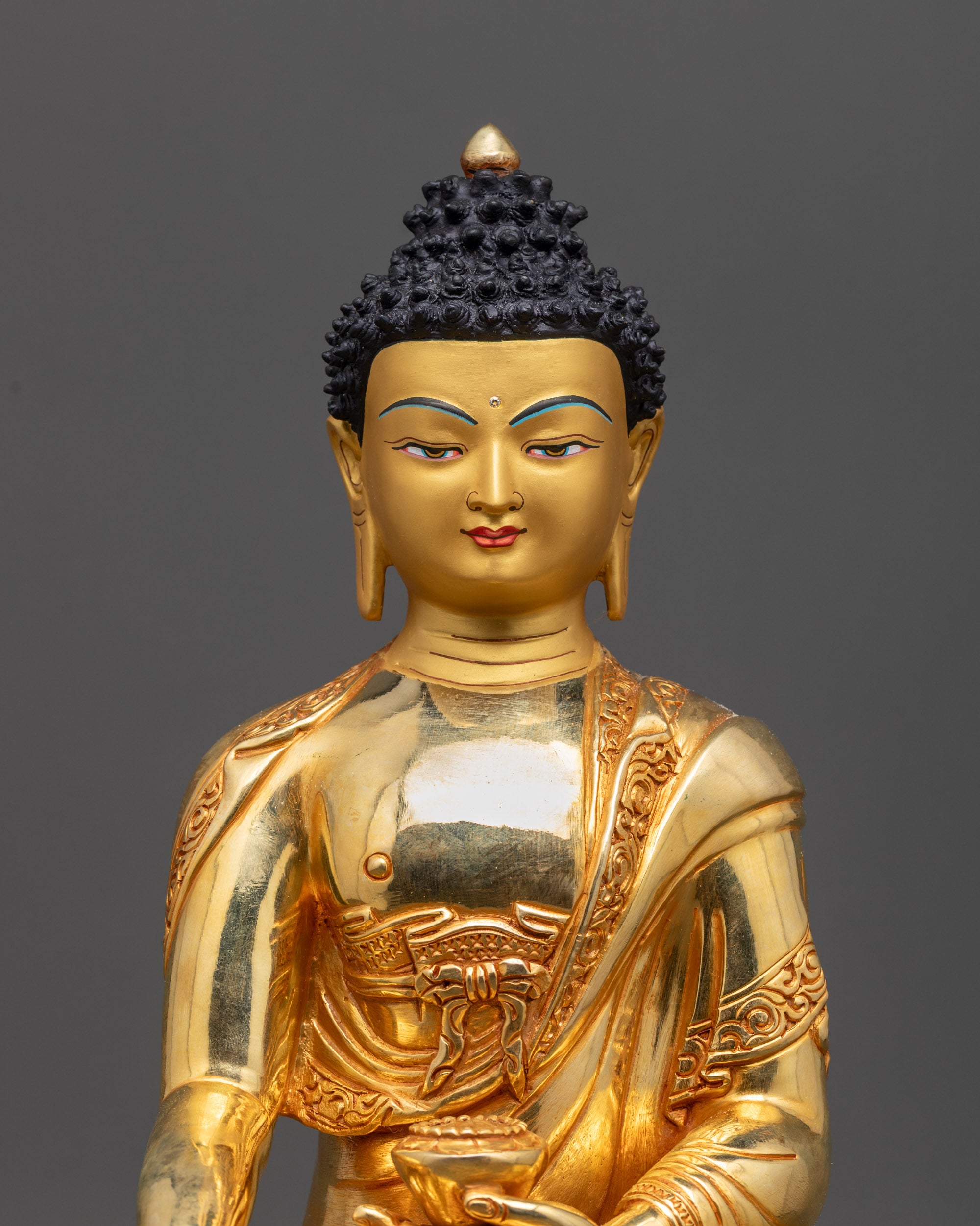 close up tranquil Shakyamuni Buddha gold-gilded face showing serene expression

