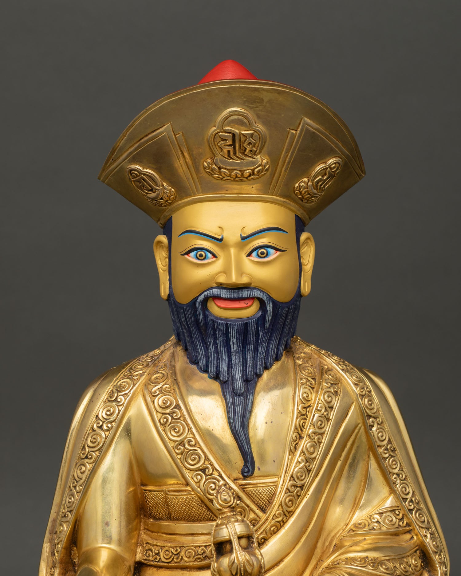 Close up of Zhabdrung Rinpoche statue with gilded robes and lama hat