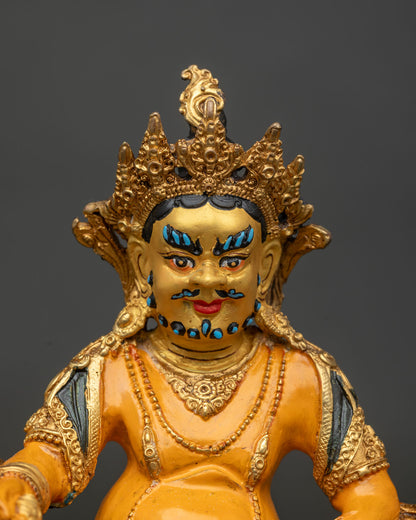 Copper Dzambhala statue with 24k gold painted face and gold gilded details.