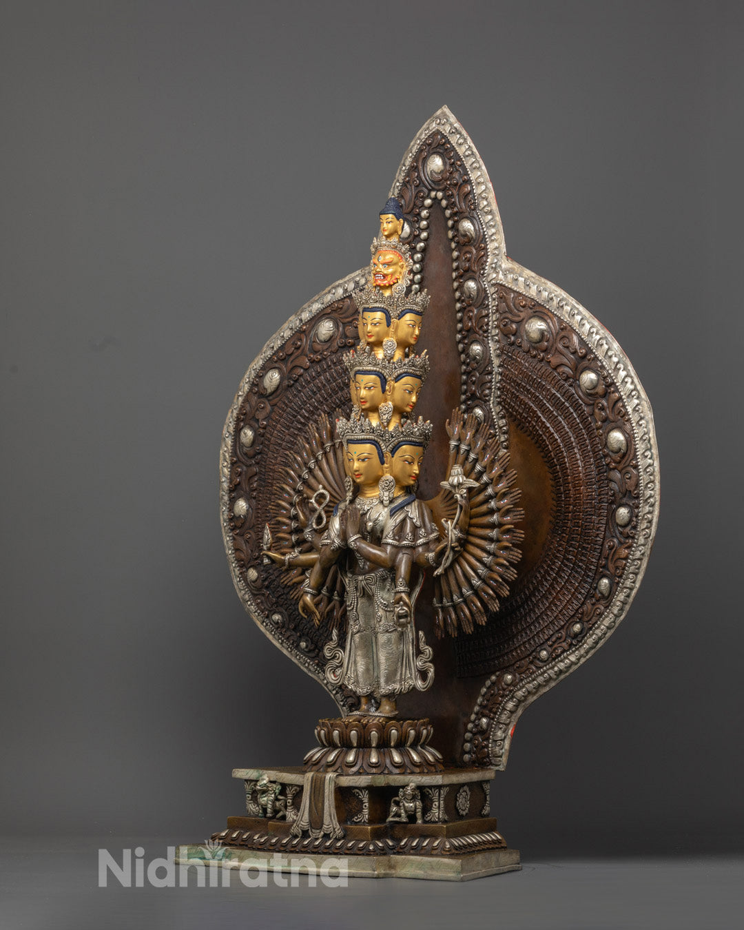 craftsmanship of lost wax method on copper body of 1000 Armed Chenrezig statue with sacred Buddhist symbolism