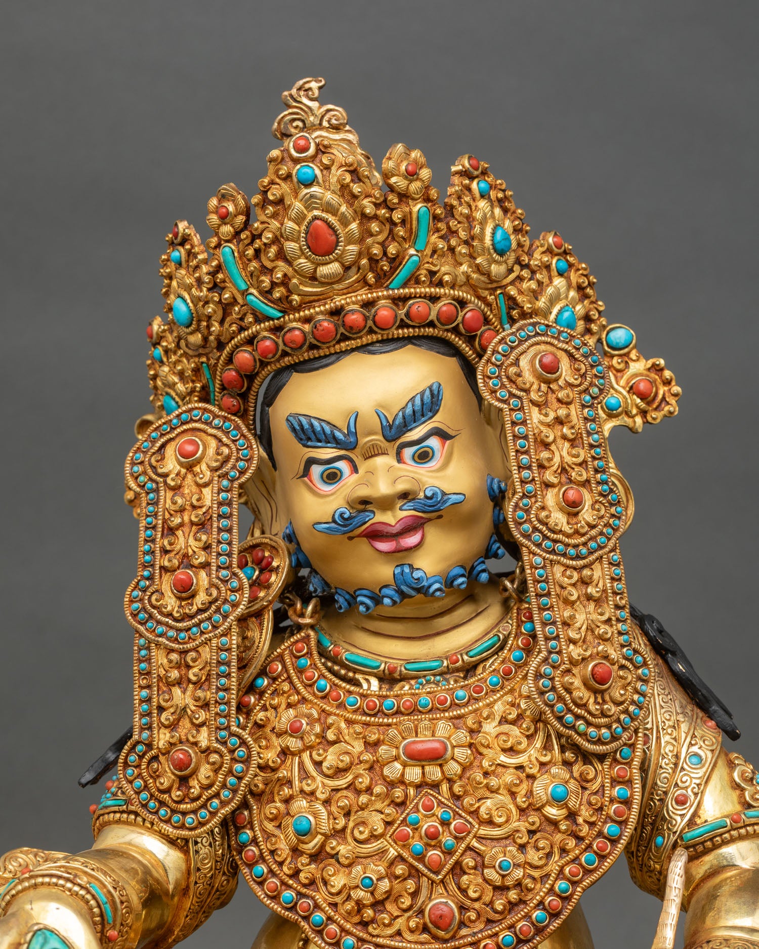 Crowned Dzambhala statue face detail cold-painted features turquoise coral inlay
