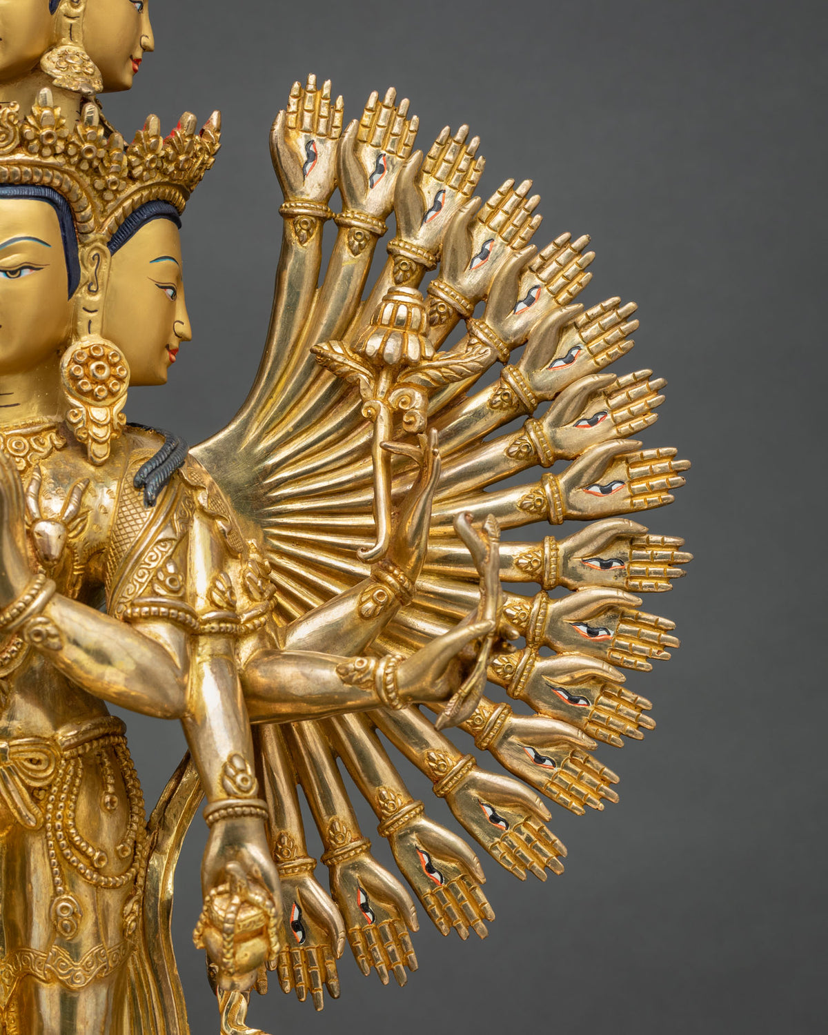 Detail of fanned thousand arms on Avalokiteshvara statue with palm eyes and sacred implements