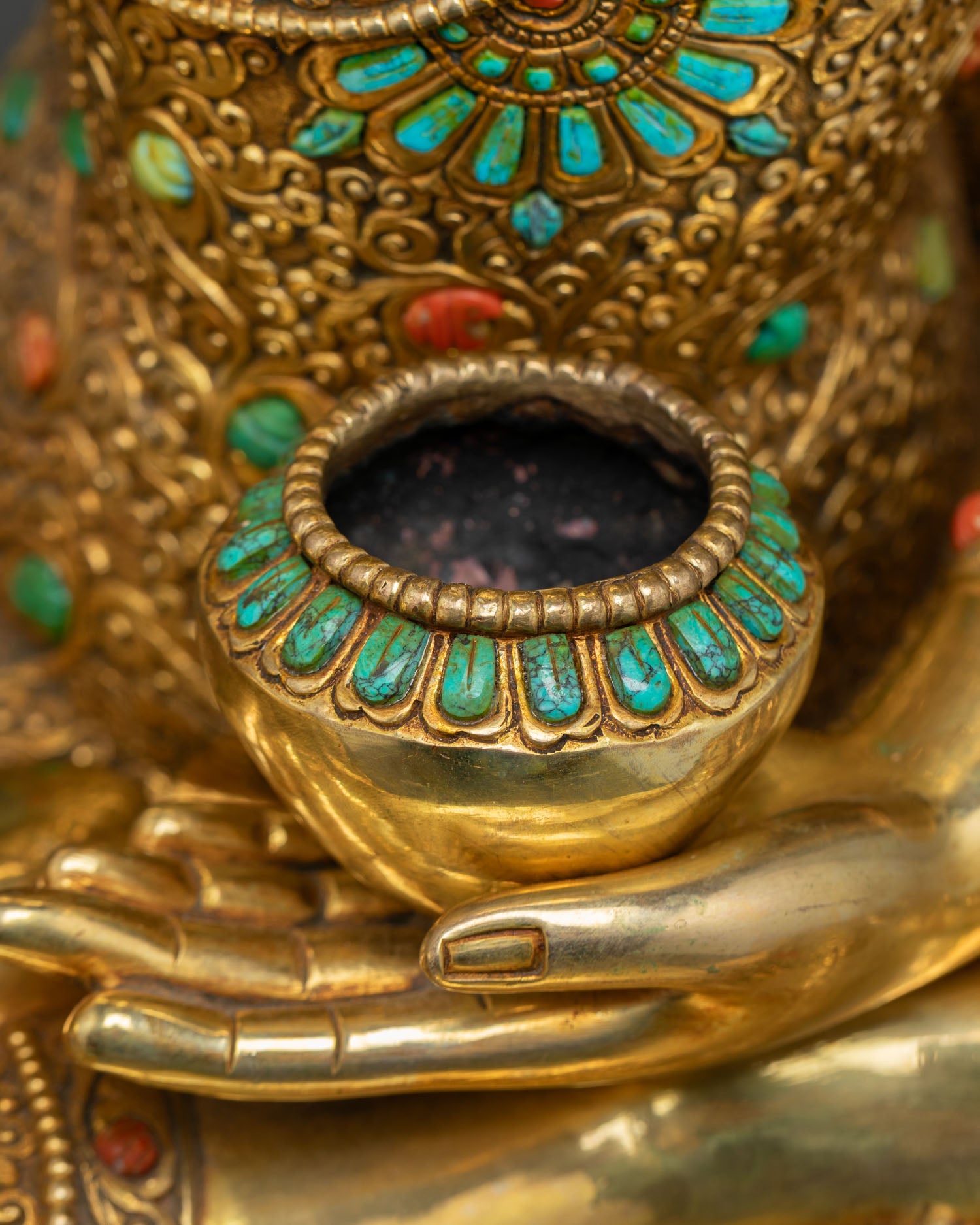 Detail of monk's alms bowl held in Buddha statue's left hand