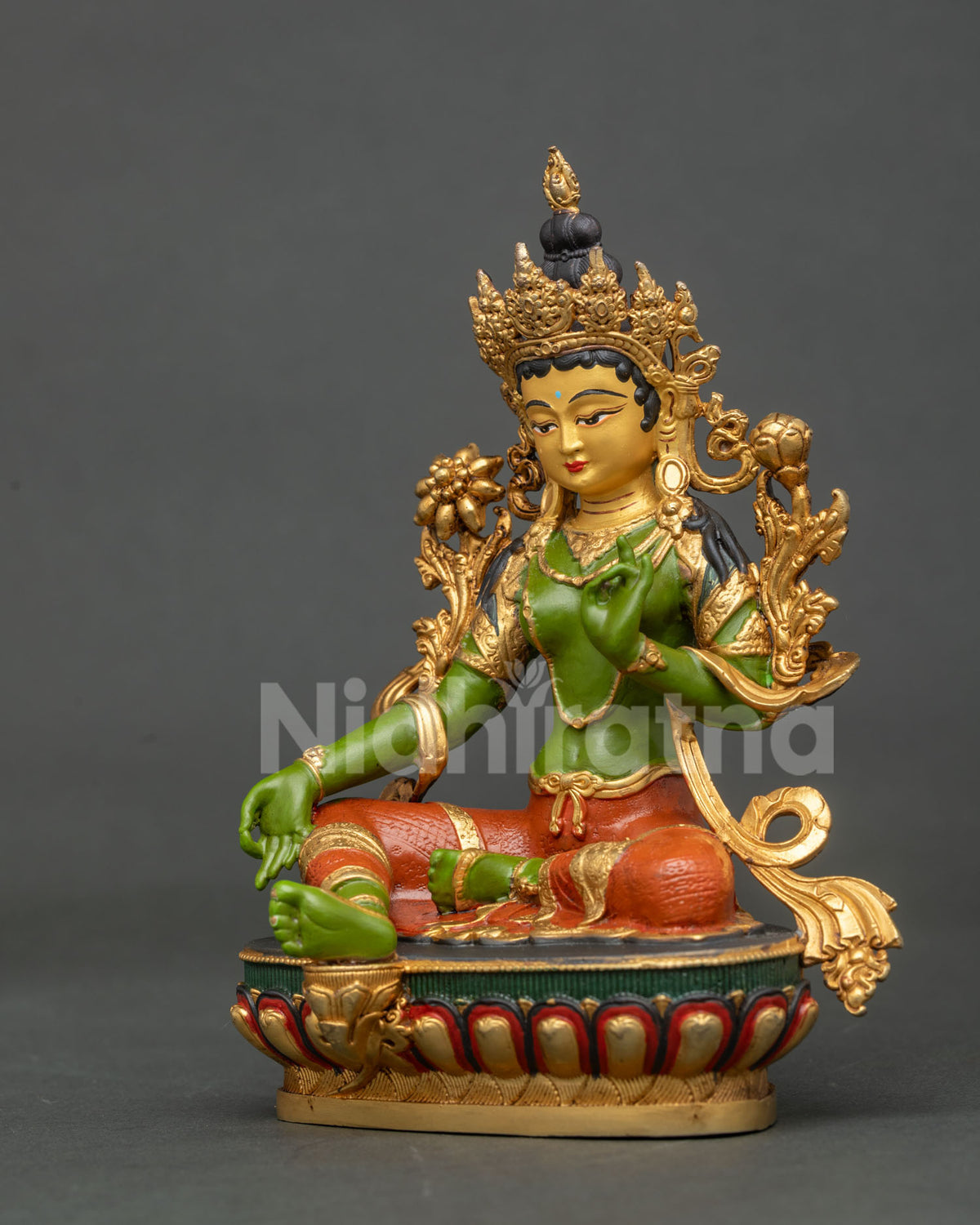 Detail view of Green Tara statue with Varada Mudra and blooming utpala lotus.