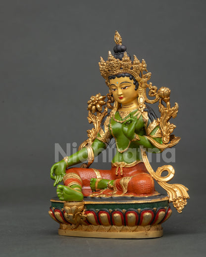 Detail view of Green Tara statue with Varada Mudra and blooming utpala lotus.
