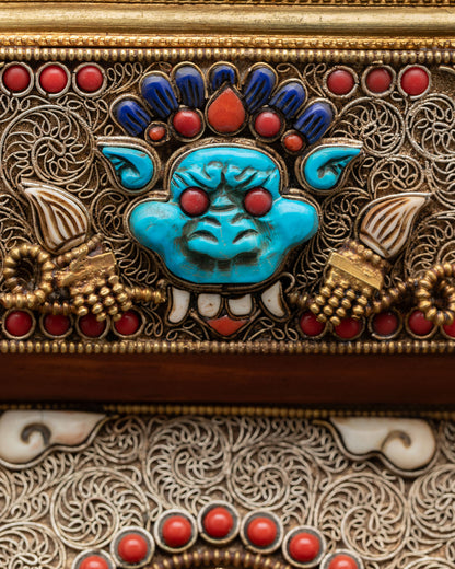 Detail view of upper mandala showing Garuda symbol intricately crafted in copper gold plated finish representing protection and removal of obstacles