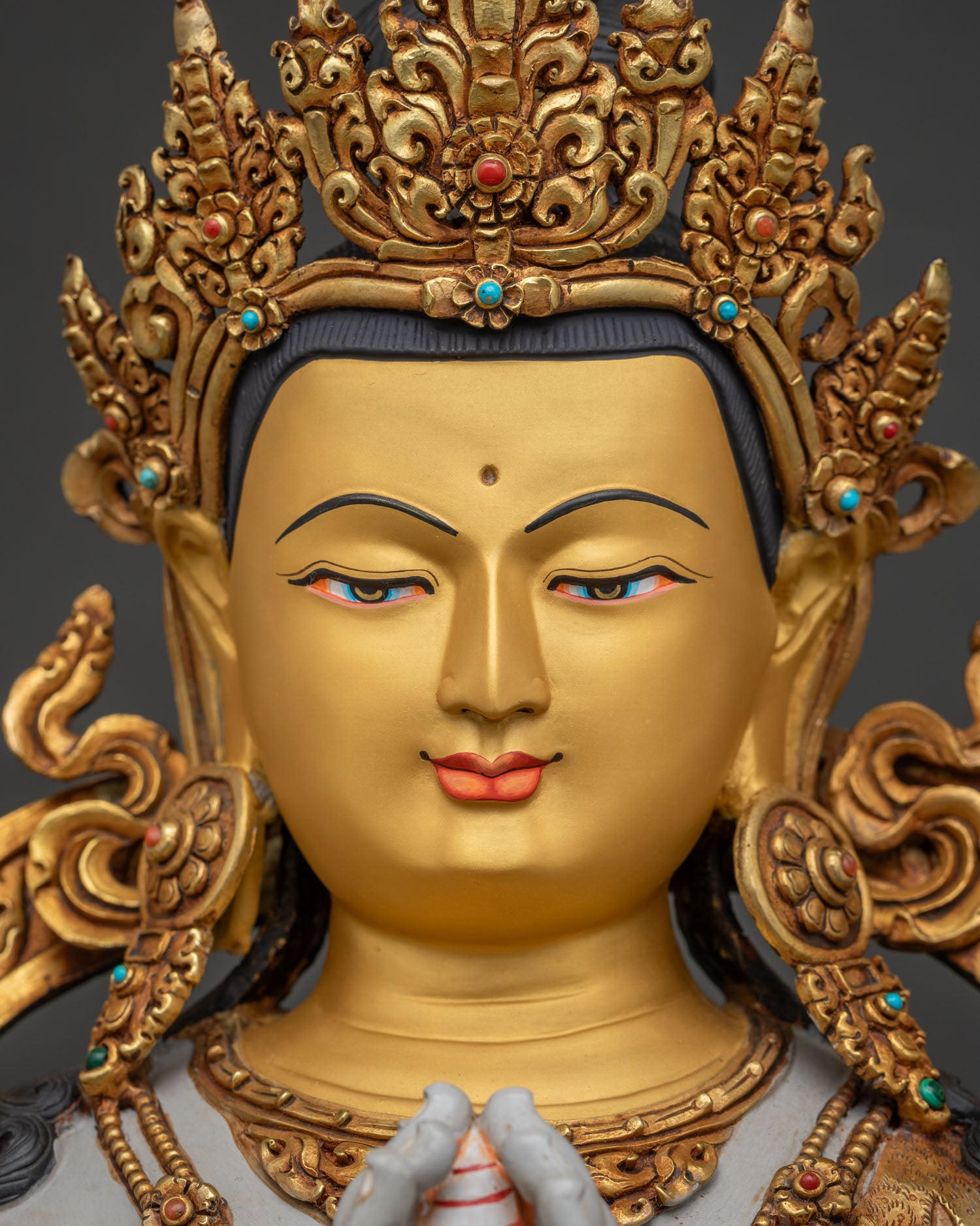 Detailed Chenrezig Avalokiteshvara statue face with 24K gold-painted features