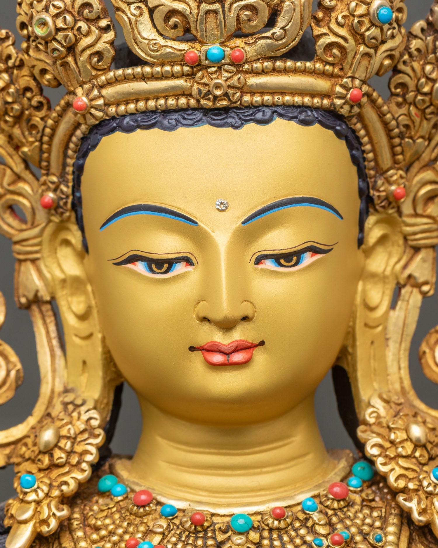 detailed close up face of maitreya buddha statue gold-painted serene expression on altar