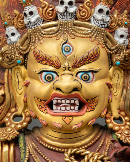 Detailed close up face of Vajrapani statue showing wrathful expression, gold painted features, and intricate ornaments