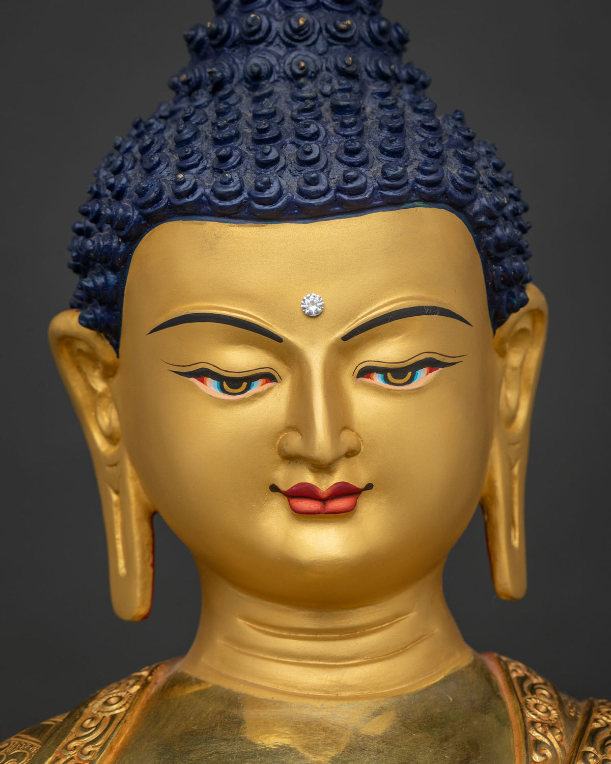 Shakyamuni Buddha serene gold-painted face with half-lidded enlightened gaze