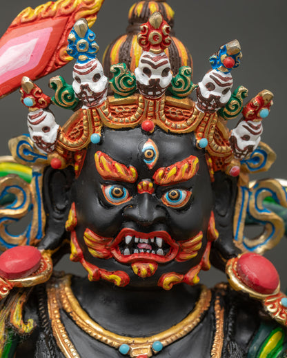 Detailed close-up of Black Manjushri's fierce face with gold paint and turquoise gemstone crown