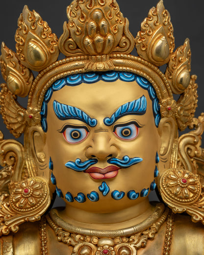 Detailed close up of Dzambhala statue face with jeweled five point diadem and expressive eyes