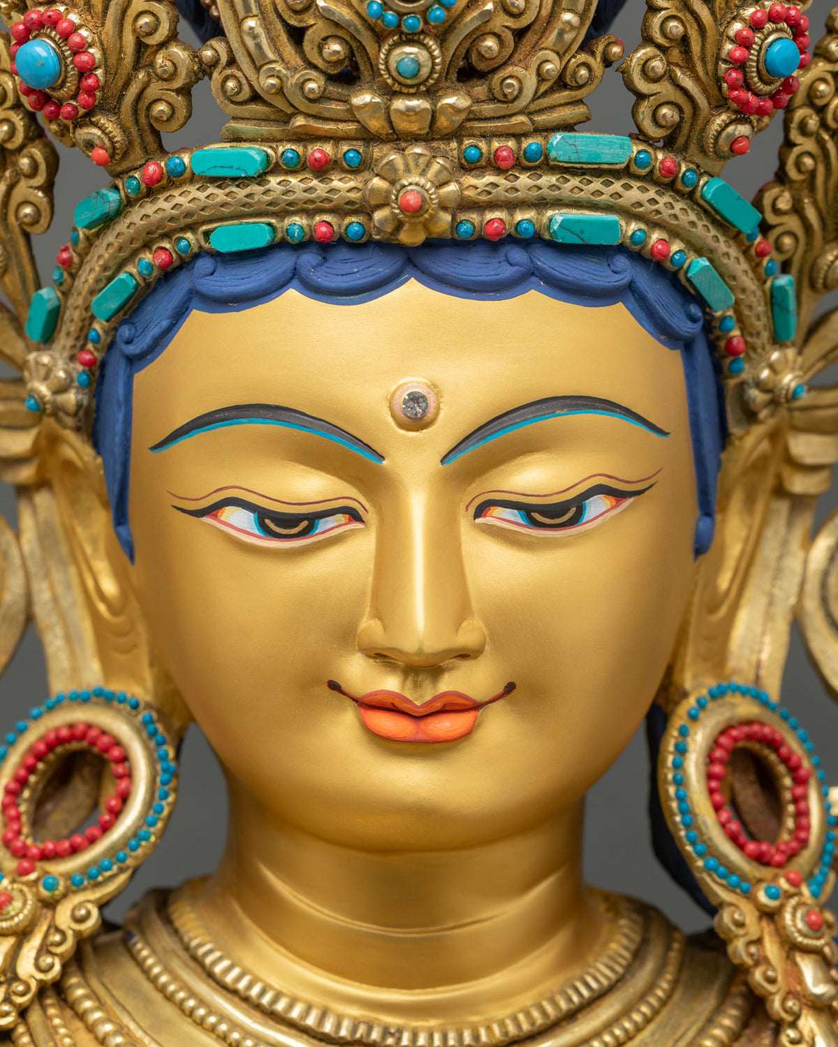 Detailed Close-up of Green Tara statue face and jeweled crown with turquoise and coral inlay