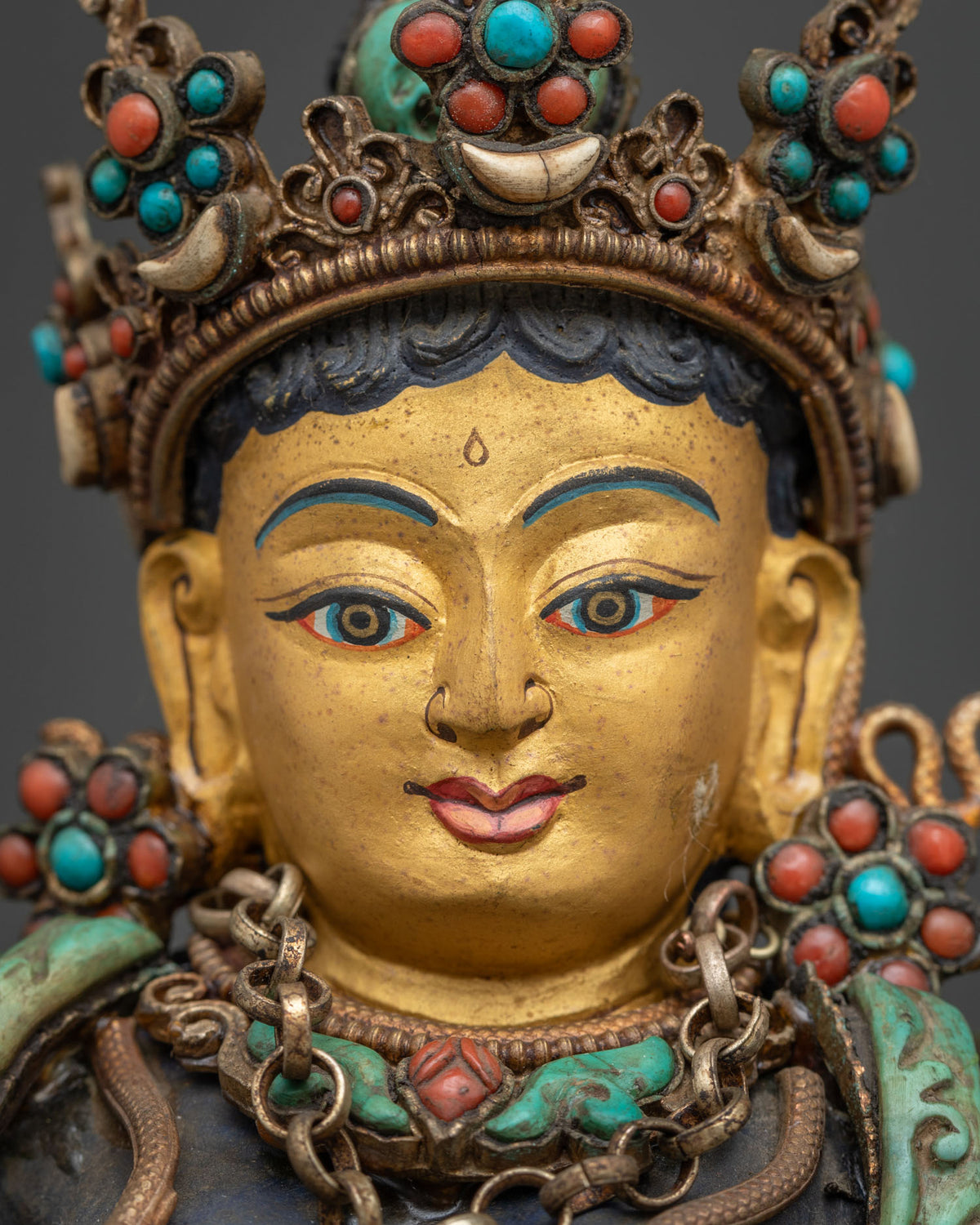 Detailed close up of Green Tara statue gold-painted face hand carved from genuine lapis lazuli