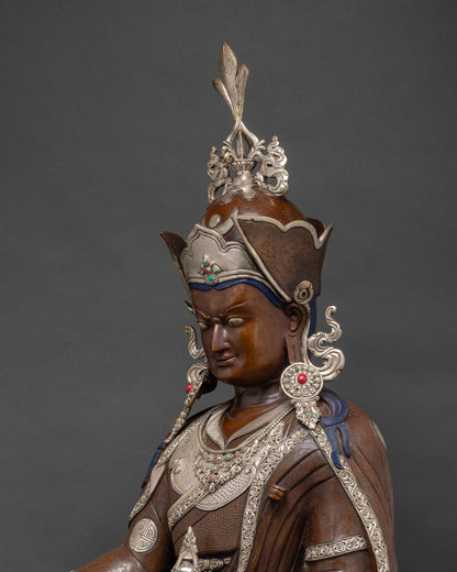 Detailed close-up of Guru Rinpoche face wearing silver-plated lotus hat with gemstones.
